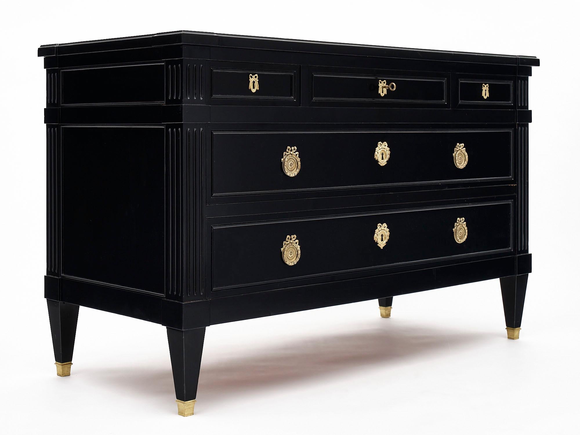 Louis XVI style grand chest of drawers from France made of solid cherrywood that has been ebonized and finished in a lustrous French polish. We love the brass hardware and capped feet as well! There are three dovetailed drawers above two lower
