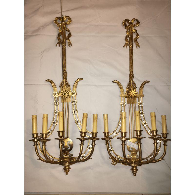 Pair of Louis XVI style Harp back bronze wall sconce. This fine pair reminiscent of the Hollywood Regency Era are all solid bronze. Each having a harp back design with crystal rosettes throughout. The flowing back-plate adorning eagle heads looking