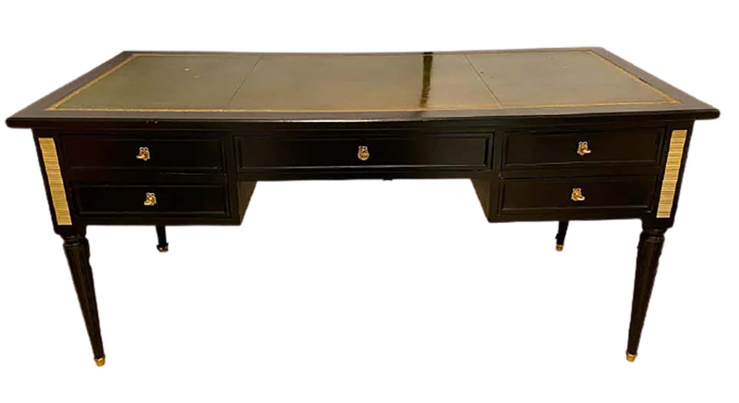 Louis XVI Style Hollywood Regency desk in Manner Maison Jansen. This exceptional ebony and bronze mounted large and impressive desk can easily sit center room as it is finished on all sides. Having a green Leather gilt tooled writing top with a