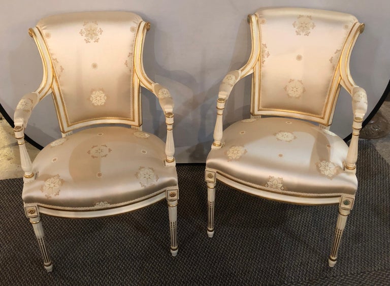 Pair of Louis XVI style Hollywood Regency fauteuils or armchairs in a stunning Scalamandre silk upholstery. I have four pair of these wonderfully decorative and upholstered armchairs available. Each finish in a matching cream paint decorated frame