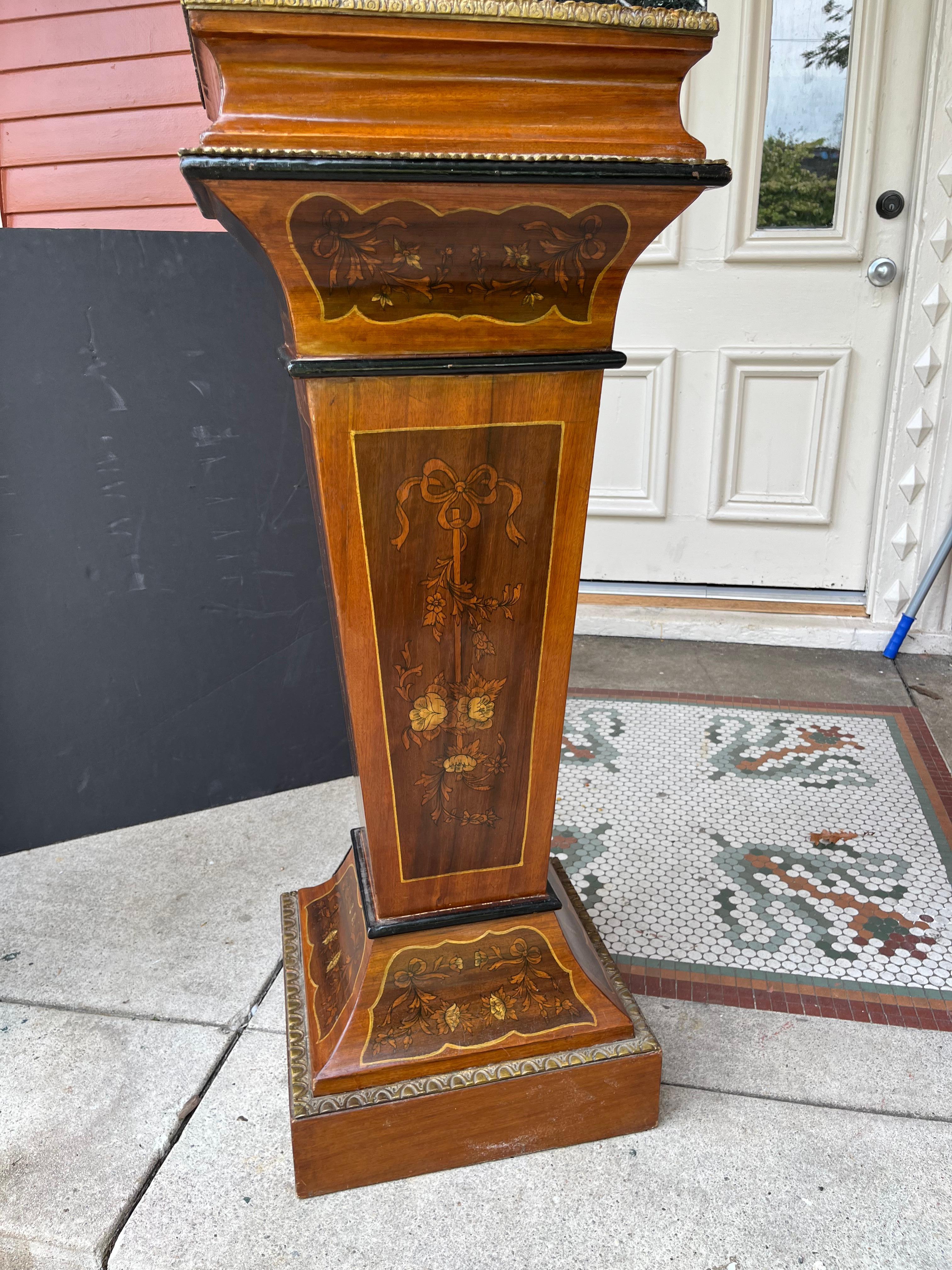 The pedestal with floral decoration in set panels on all 4 sides .Some in-Painting or stenciling to heighten sense of contrast.

This style pedestal was originally designed to hold clocks ,busts, urns or vases .Often finished ( as is this one )in