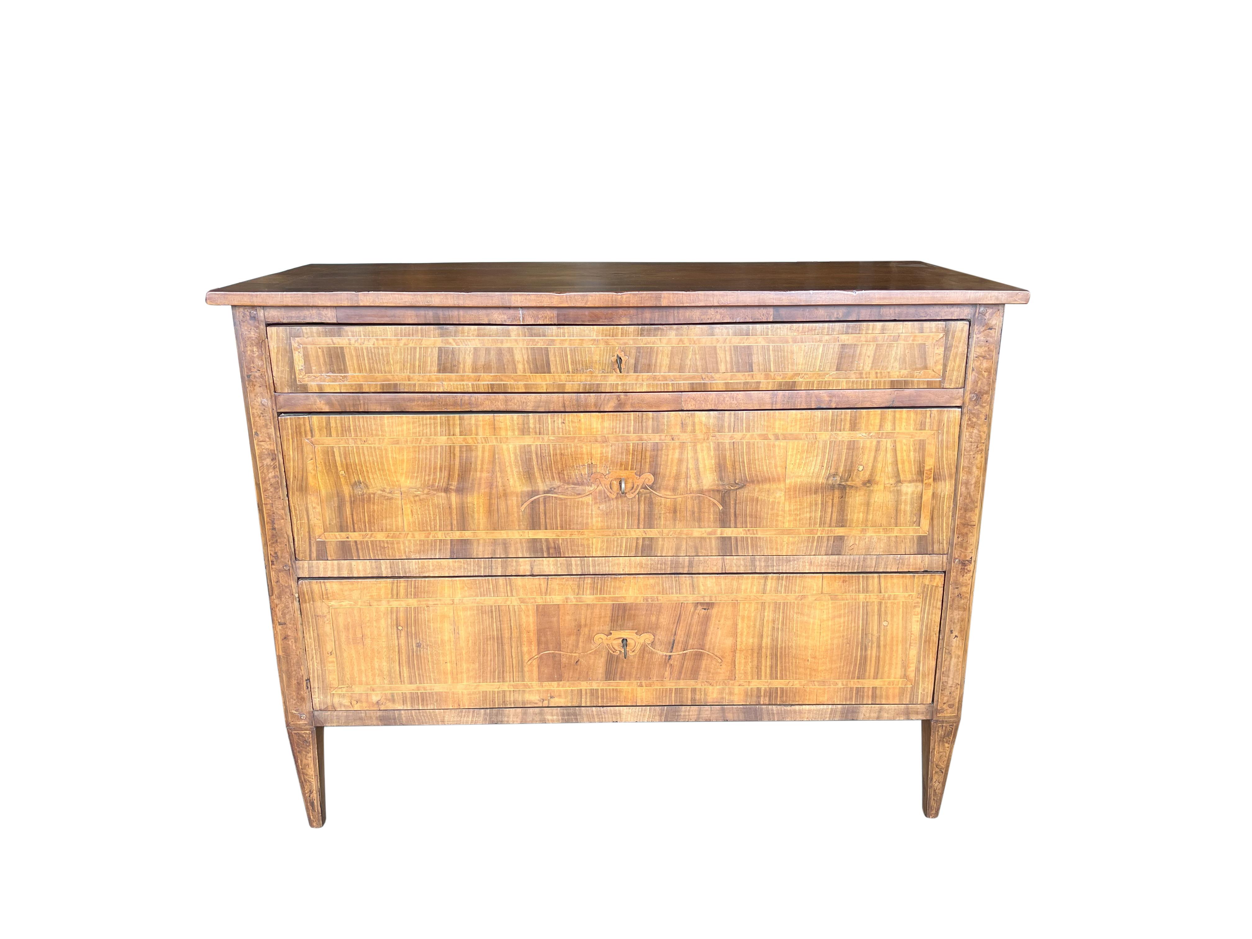 Elegant Louis XVI Style Italian walnut chest of drawers with burl inlay, Tuscany circa 1890. Three drawers with dovetail joinery, separate locks & keys. Fine arts & crafts detail exhibited in a trim, modern form. Trophy floral marquetry centerpiece