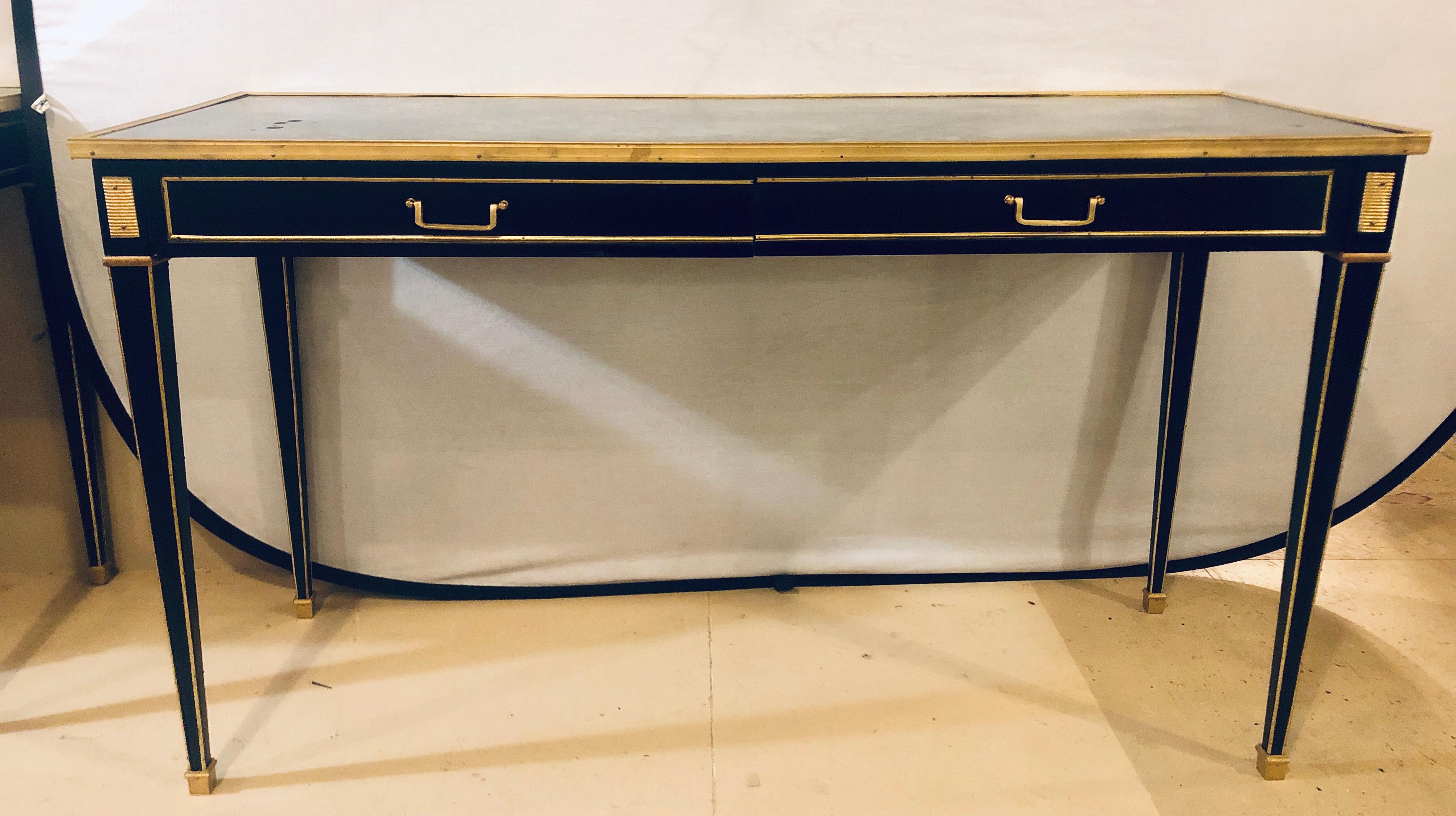 Pair of Ebony Maison Jansen style mirror top 2-drawer console with bronze mounts. Each having tapering legs with bronze mounts and cookie cutter corners. Each with an antiqued mirror top.
joy.