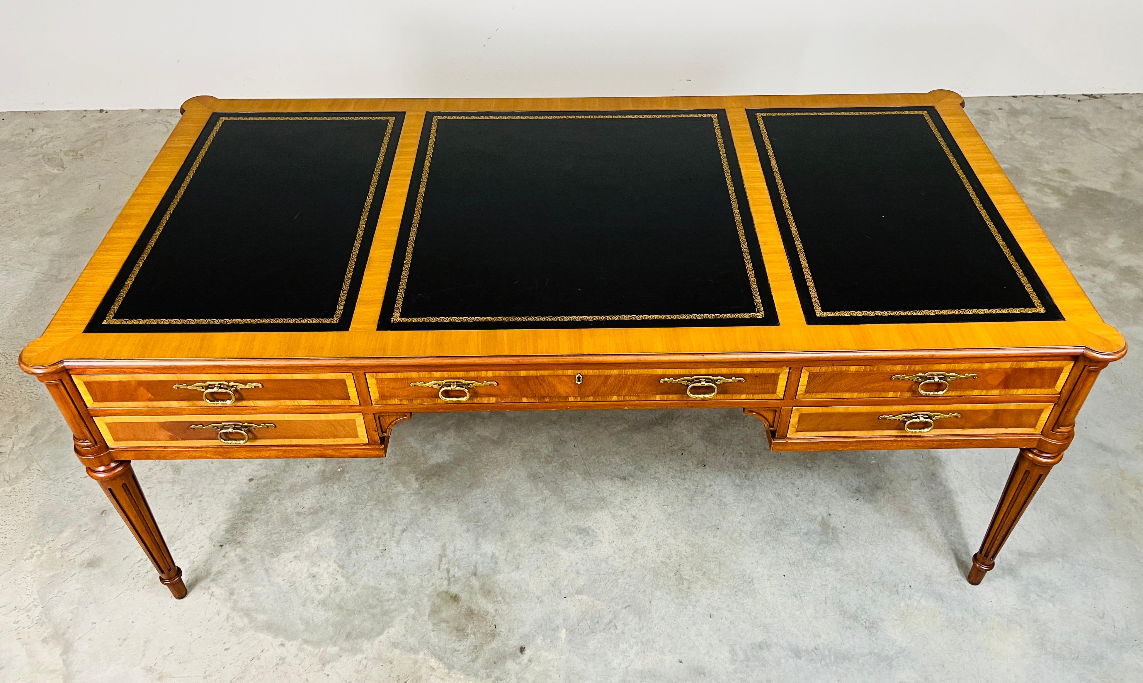 
Un'elegante scrivania direzionale in stile Luigi XVI in mogano massiccio con intarsi a fasce in legno satinato e piano in pelle nera con bordi dorati. Cinque cassetti e cinque falsi cassetti sul retro con tiretti in ottone massiccio su gambe