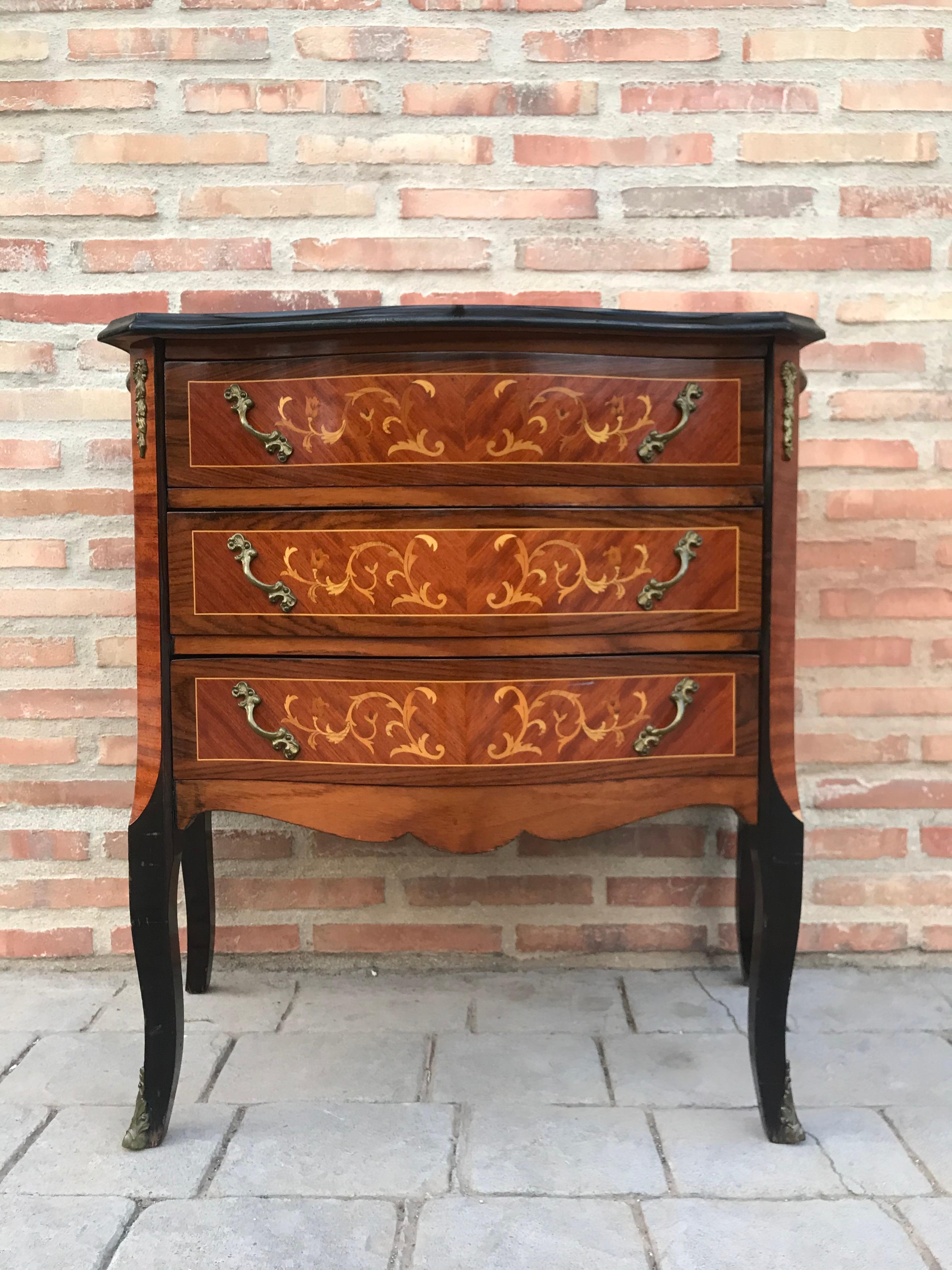 Kingwood and marquetry commode, in Louis XVI transitional style, of serpentine bombe form, fitted three drawers above a shaped apron and tall angular splayed legs, inlaid with panels of flower sprays, swags and pendants, gilt brass foliate