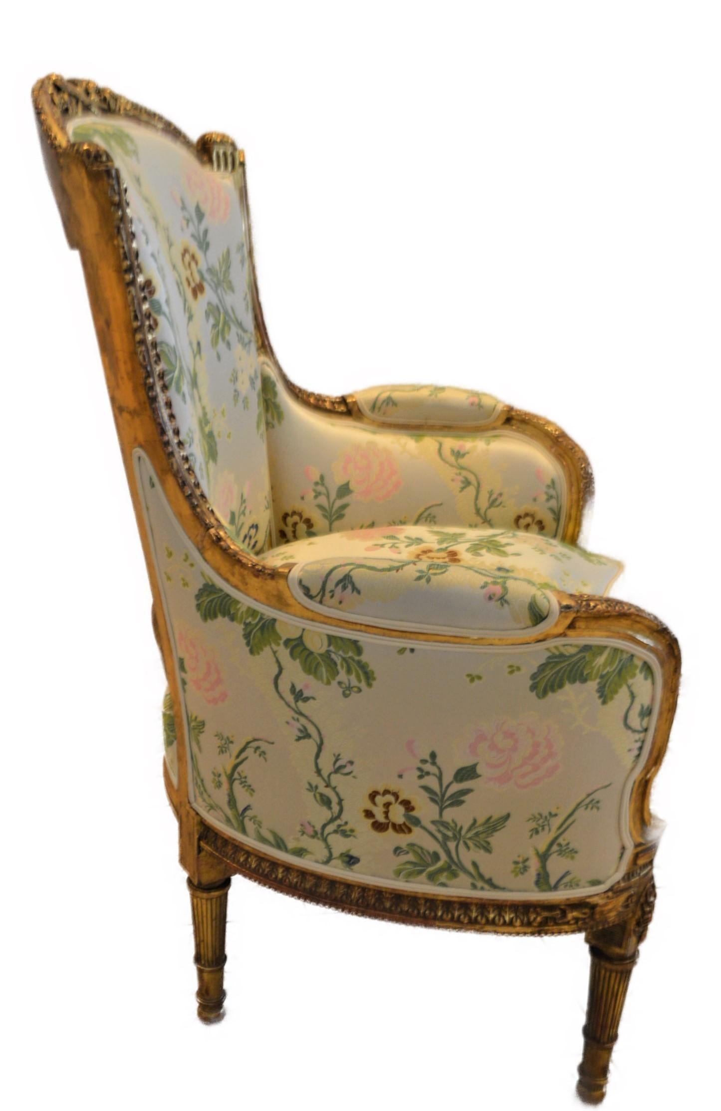 French Louis XVI style leaf gilded bergere chair, hand carved, silk botanical fabric.