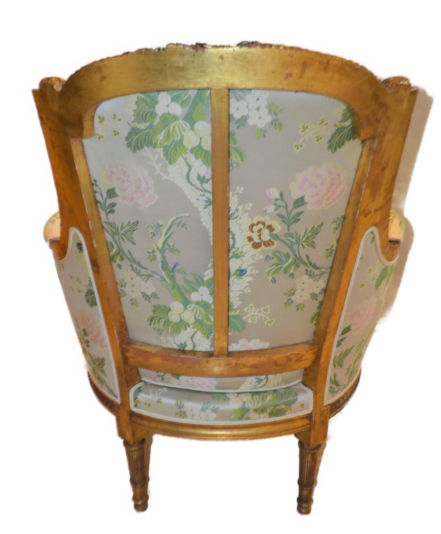 Gilt Louis XVI style leaf gilded bergere chair, hand carved, silk botanical fabric.