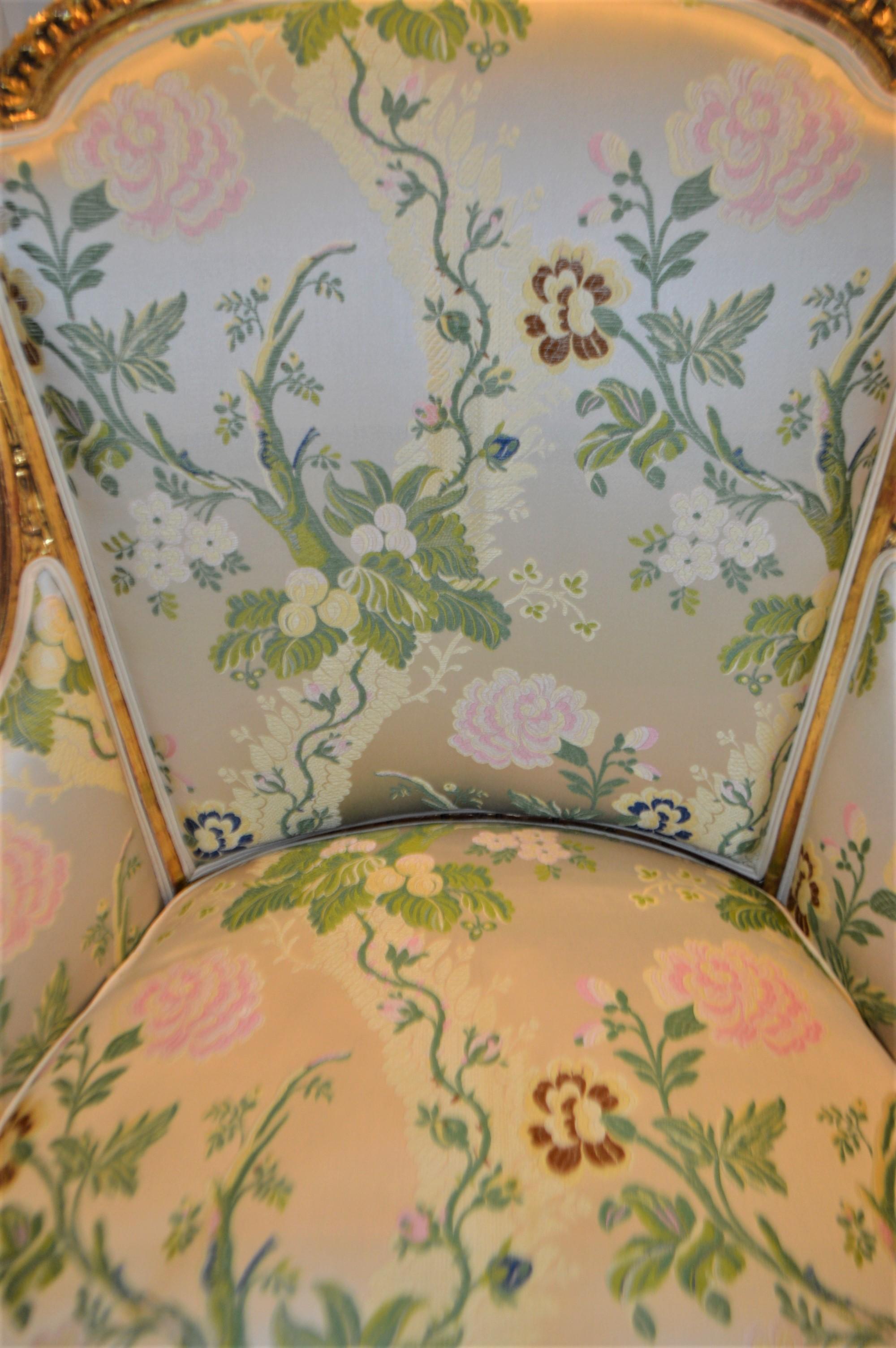 19th Century Louis XVI style leaf gilded bergere chair, hand carved, silk botanical fabric.