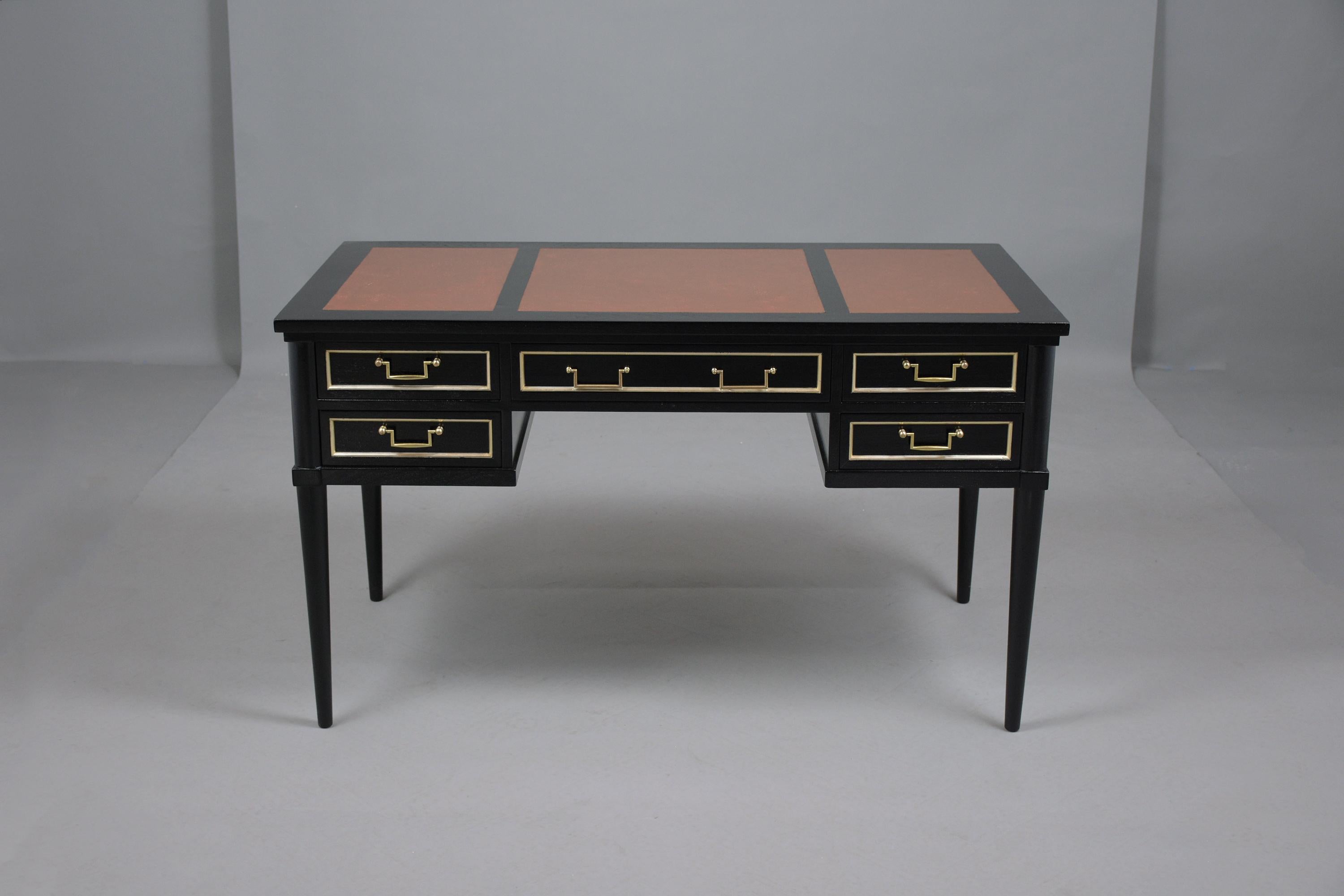 This 1950's Louis XVI style desk has been professionally restored and features its original faux leather top dyed in a cognac color waxed and polished developing a beautiful patina This English writing table has been newly stained in a rich ebonized