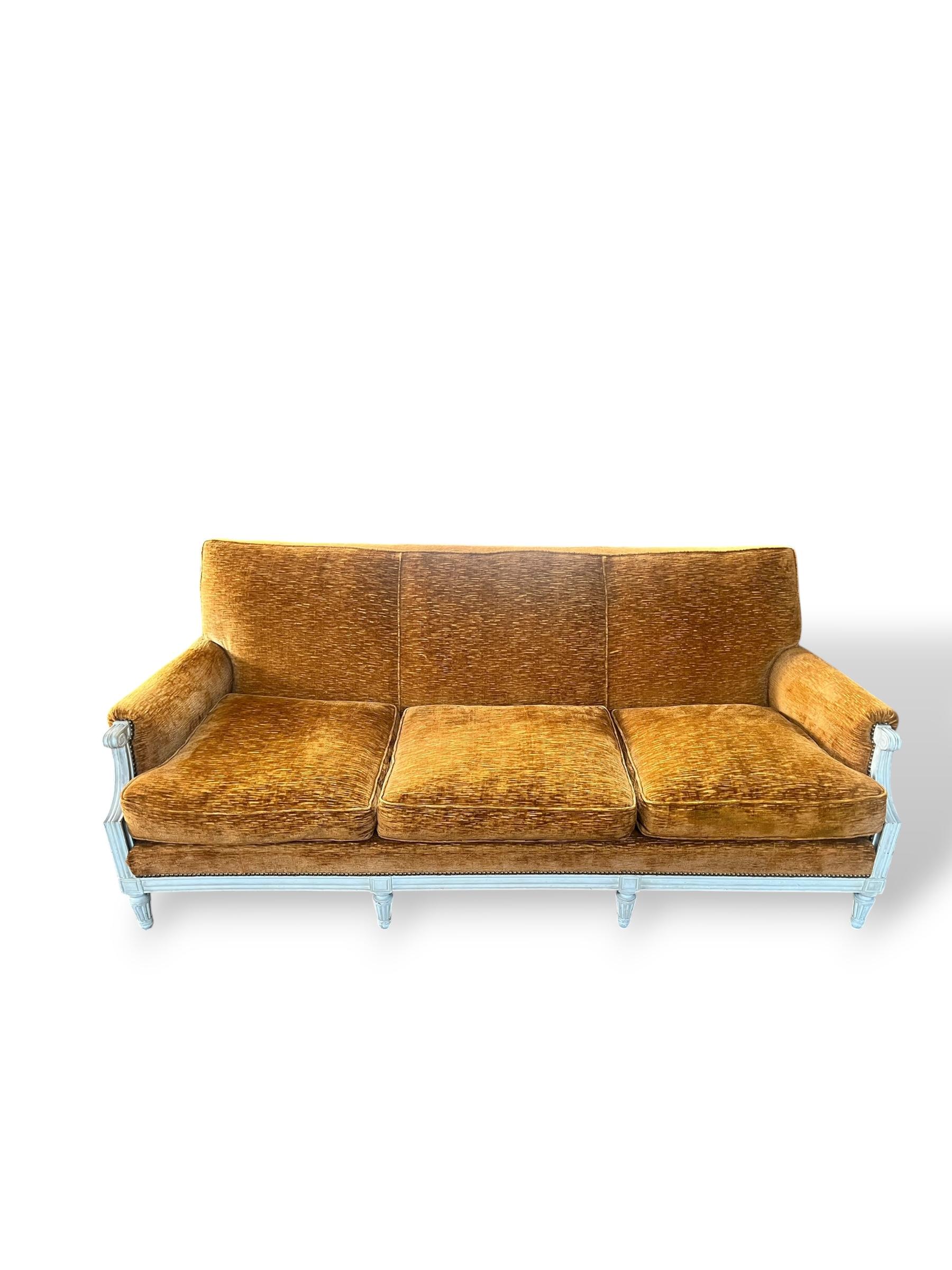 Elégant ensemble de salon de style Louis XVI des années 1970, composé d'un canapé trois places et de deux grands fauteuils. L'ensemble repose sur un cadre en bois finement travaillé, laqué clair, aux lignes droites et sobres, typiques de