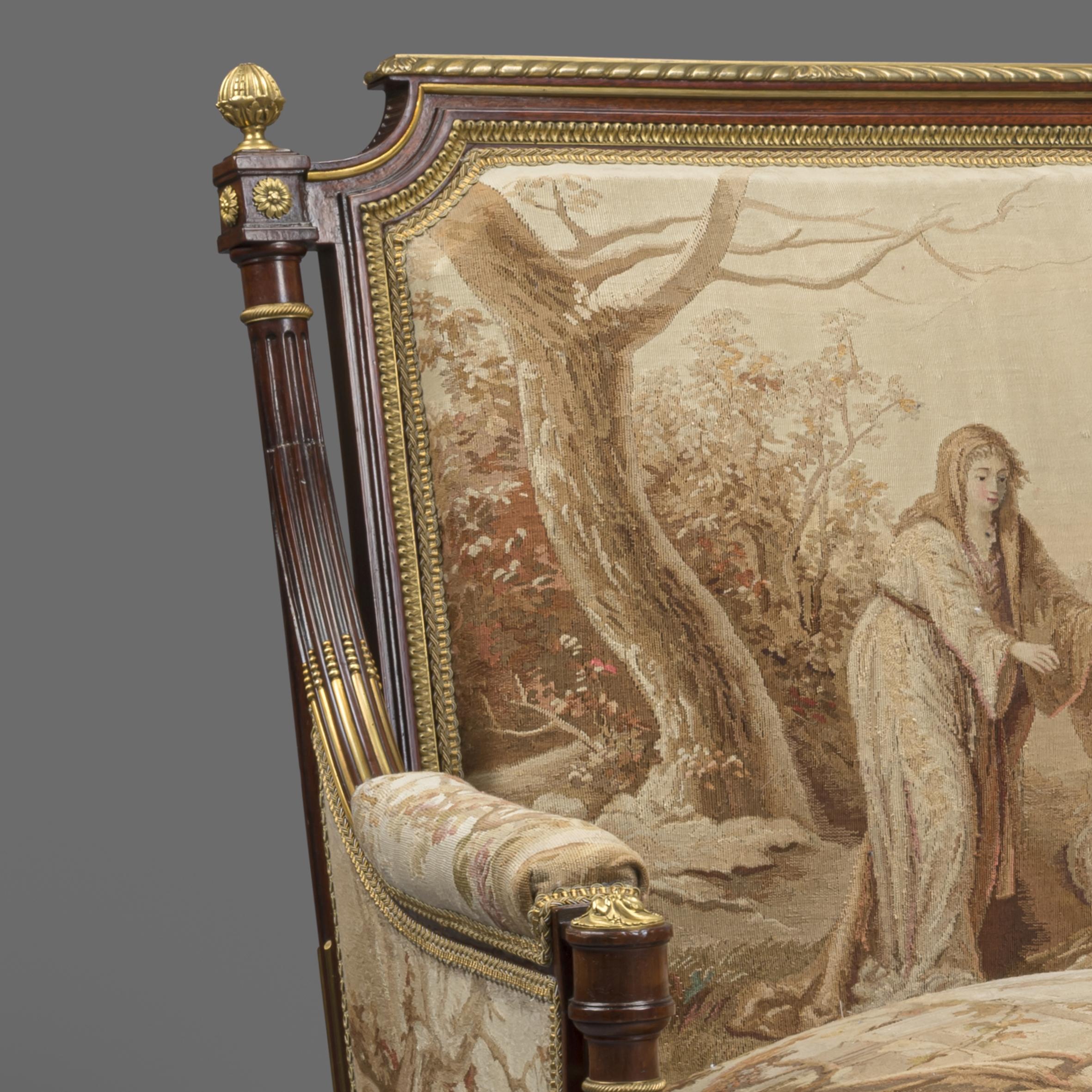 A fine pair of Louis XVI style gilt-bronze mounted mahogany and Aubusson tapestry upholstered bergeres.

This fine pair of mahogany bergeres each have a gilt bronze top rail above a rectangular back flanked by reeded columns and arms, upholstered