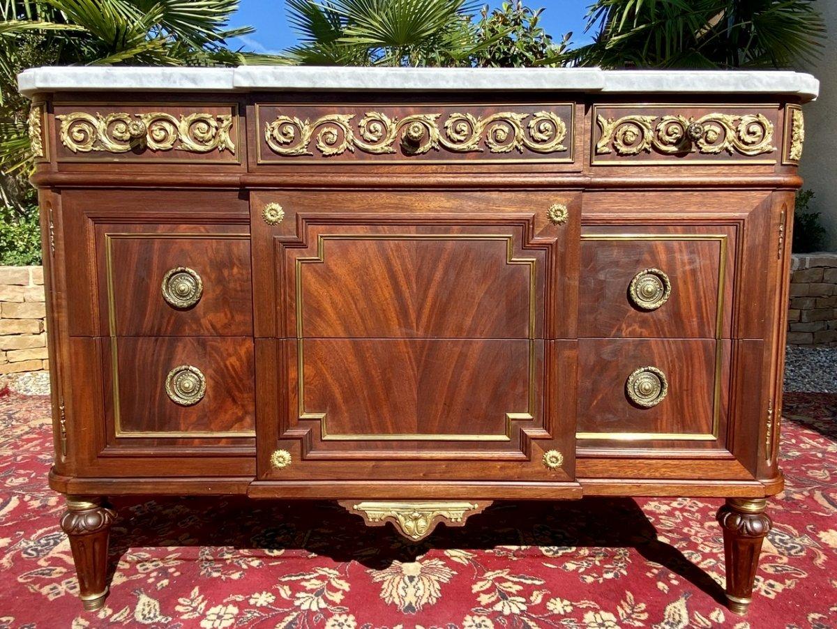 Mahogany chest of drawers and chiseled golden bronzes, Louis XVI style. It dates from the years 1920-1925. It opens with 5 drawers and is above white marble. Beautiful dresser in good condition. French work of good quality.