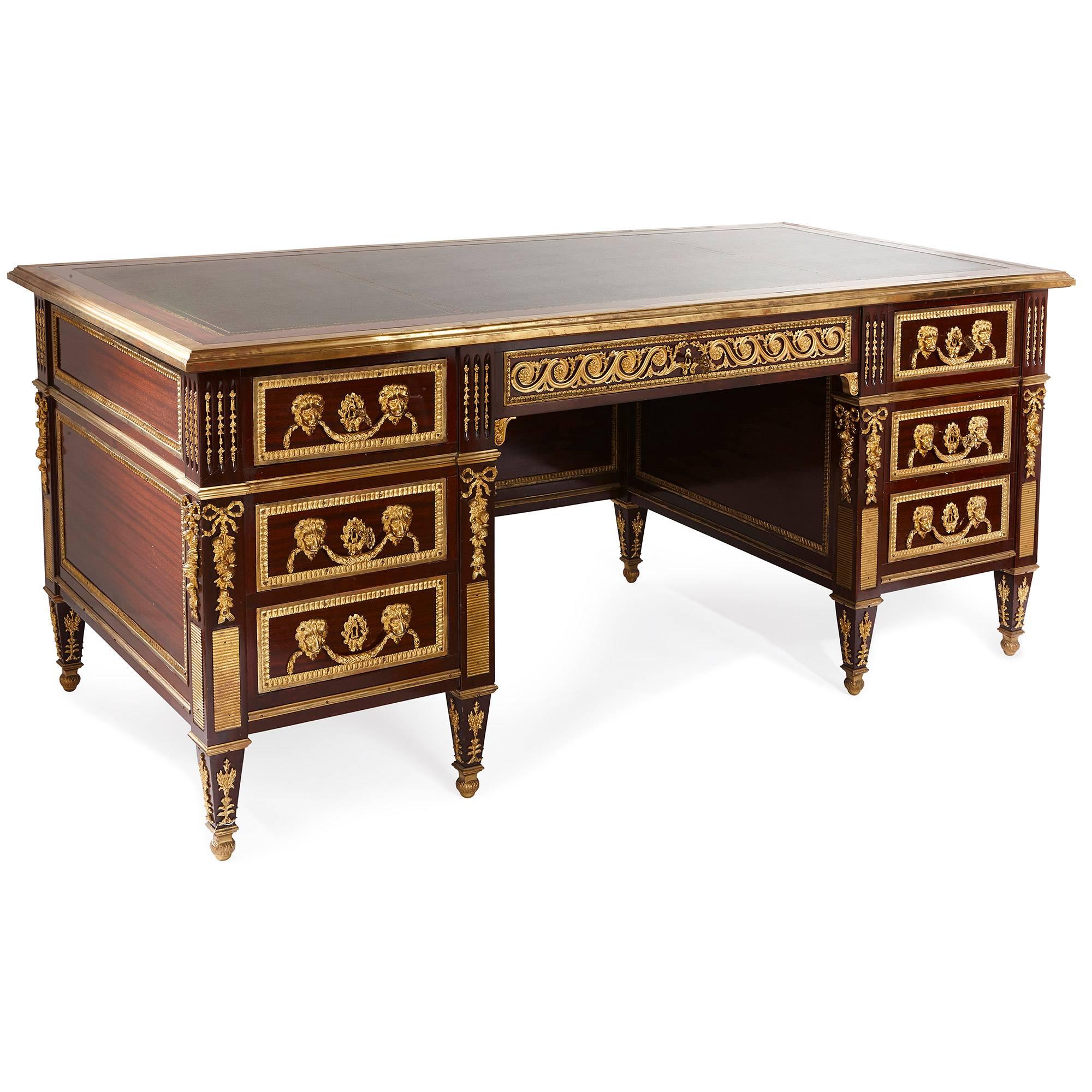 Built from mahogany, topped with leather and mounted with gilt bronze, this splendid Louis XVI style writing desk exudes neoclassical elegance and will add a sumptuous, grand touch to a traditional antique interior. The desk is rectangular in form