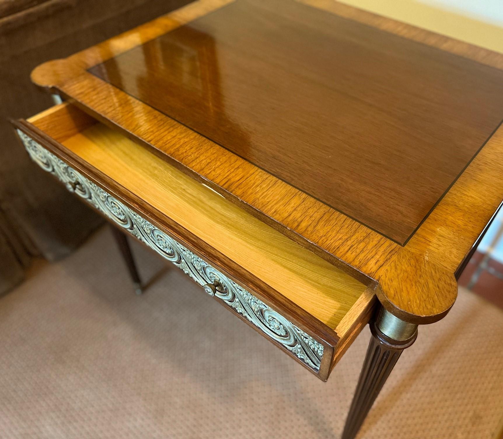 Fin C.I.C. Table d'appoint en bronze doré ornée de pieds tournés cannelés et d'un seul tiroir. Il y a de petites extensions latérales (10