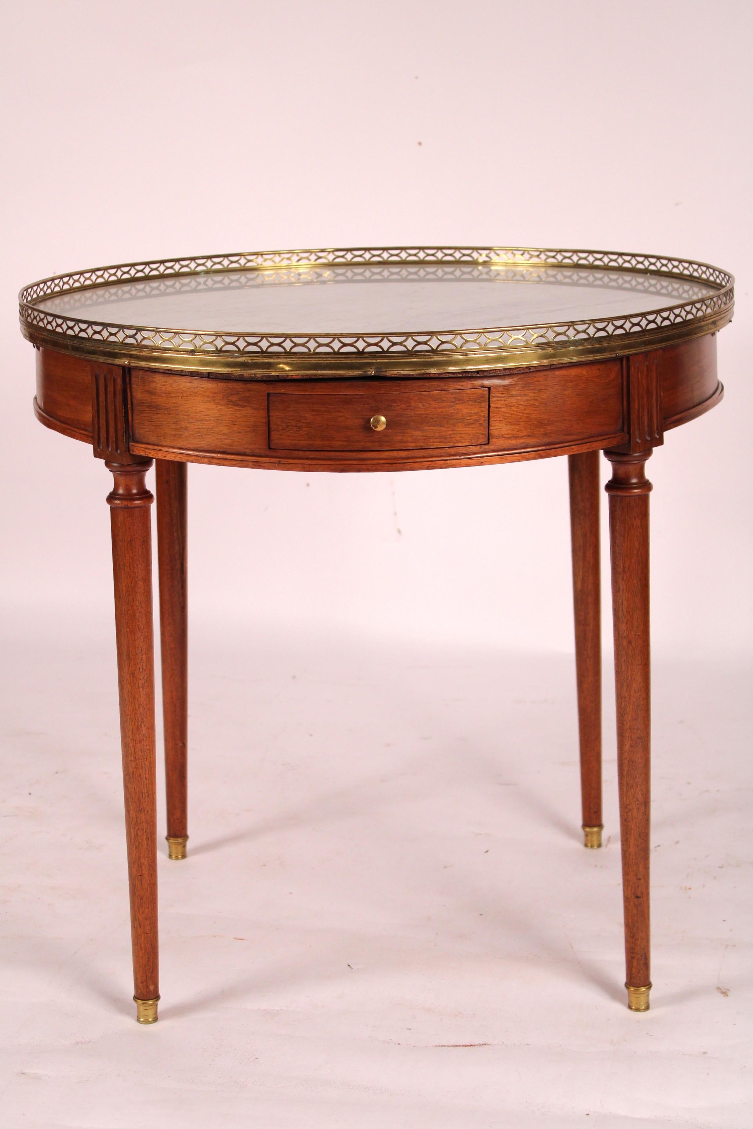 Table bouillotte en acajou de style Louis XVI, vers 1920. Avec un gris et blanc
Plateau en marbre de Carrera, galerie réticulée en laiton doré, frise à deux tiroirs et deux coulisses à bougies, reposant sur des pieds fuselés tournés se terminant par