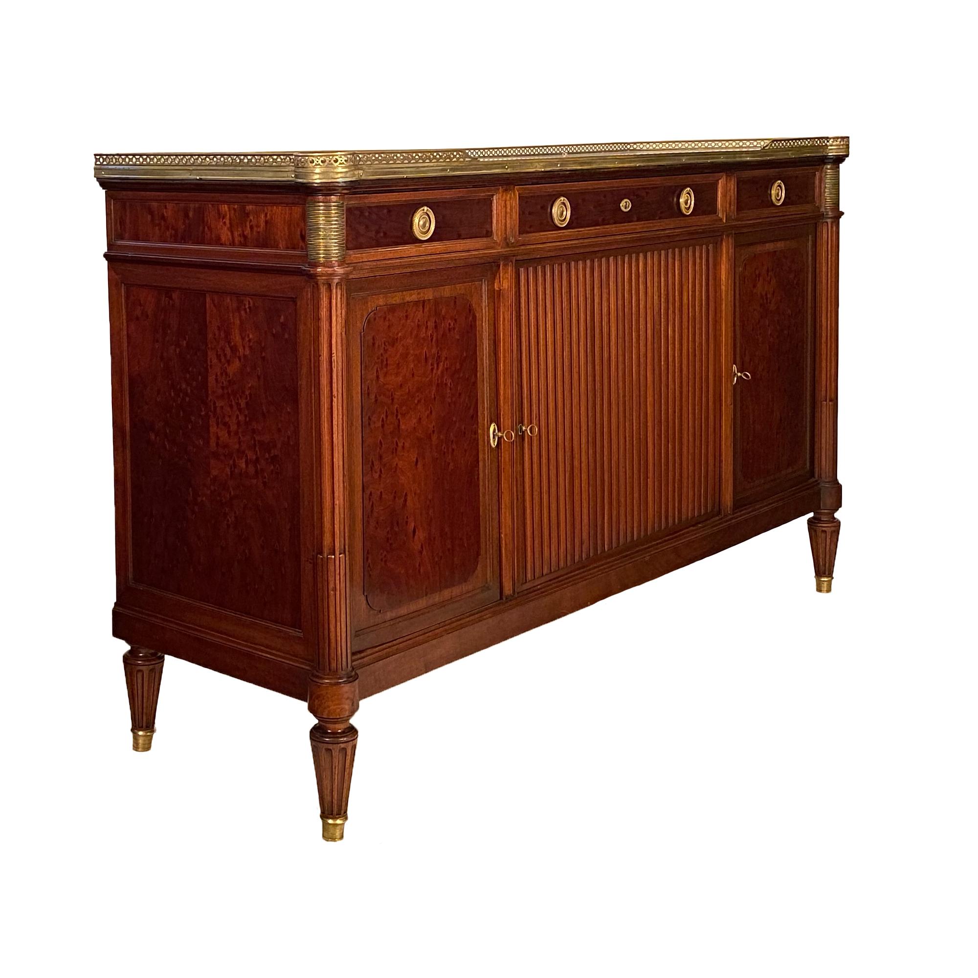 French Louis XVI style mahogany buffet. This piece is made of solid mahogany and speckled mahogany. The classic credenza opens up with three doors to ample adjustable shelving. The enfilade also features three dovetailed drawers, finely cast brass