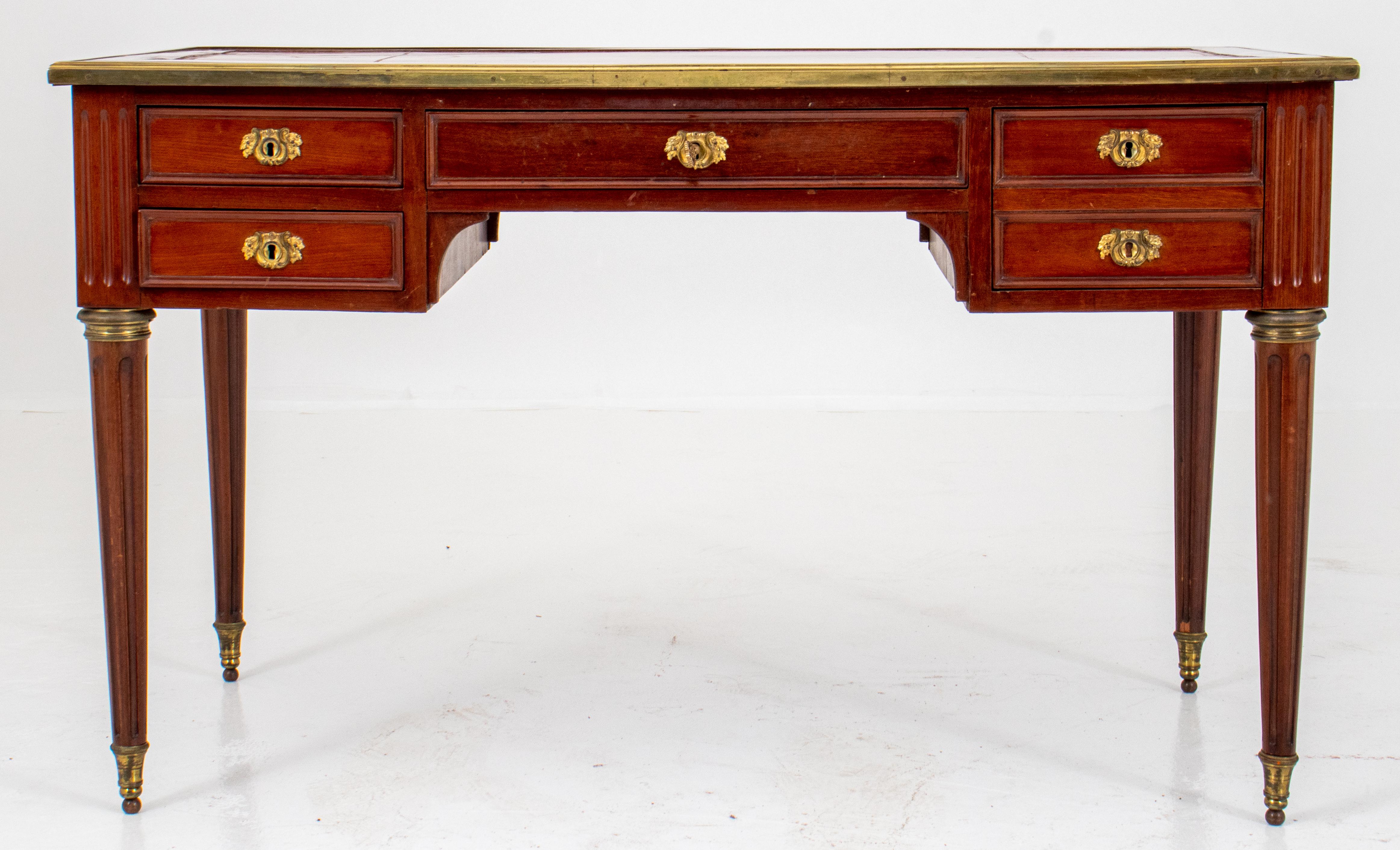 Louis XVI Style mahogany bureau plat, ca. 1900, with rectangular tooled leather inset top above five working drawers, and five blind drawers to rear, with two slides, and fluted stops above ormolu-mounted tapering fluted columnar legs terminating in