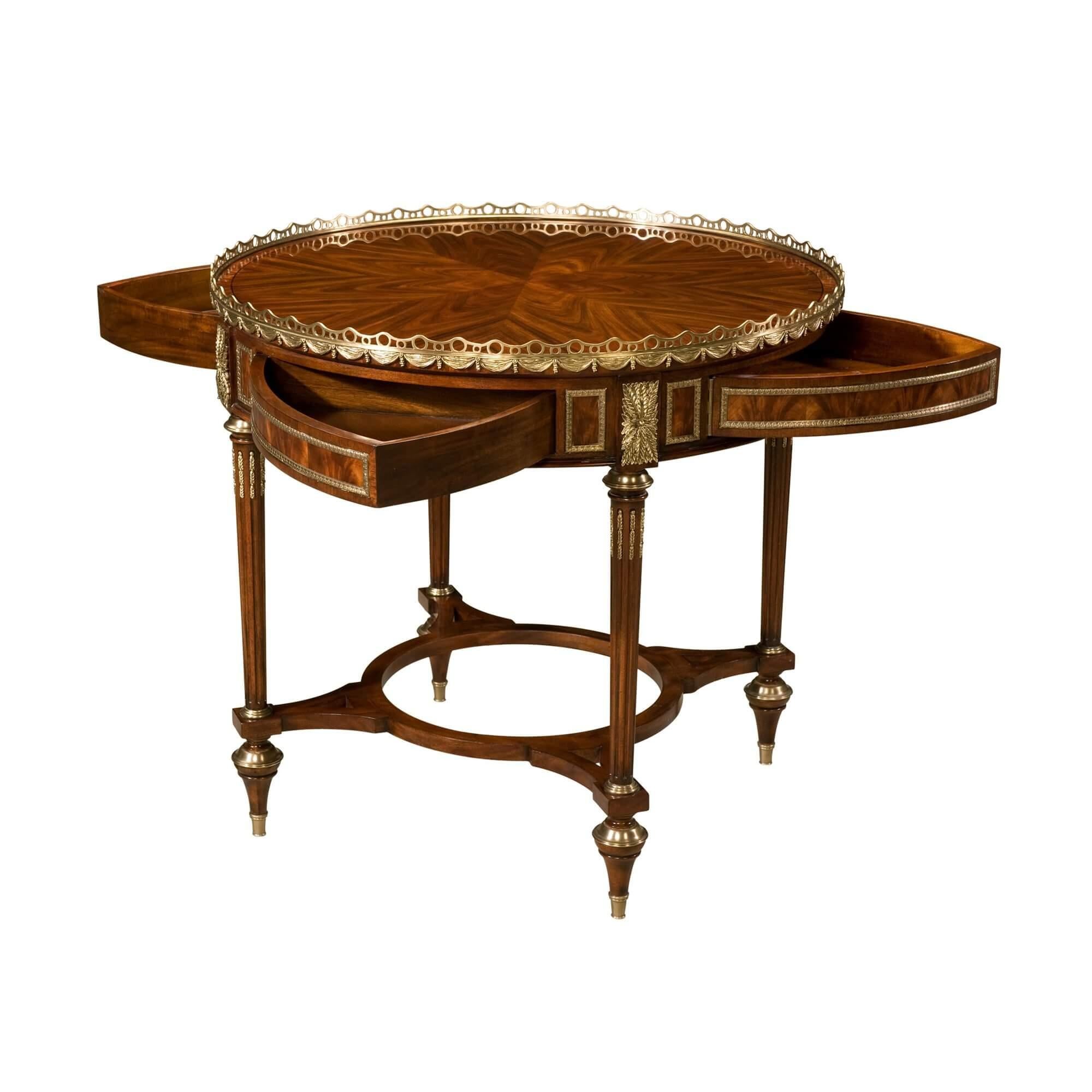 A solid mahogany, rosewood crown and flame mahogany veneered mechanical center table, the circular top with a finely cast brass gallery of repeating swags, above a brass molding paneled frieze with four frieze swing drawers opening by the turning of