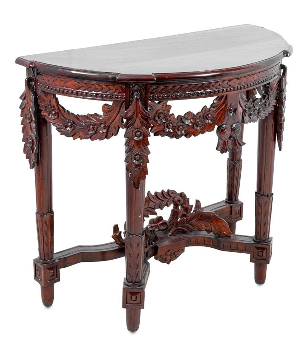 Louis XVI Style Mahogany Console Table, 20th century, the molded D-shaped top above floral swags on fluted tapering legs, joined by scrolled stretchers, and toupie feet. 33