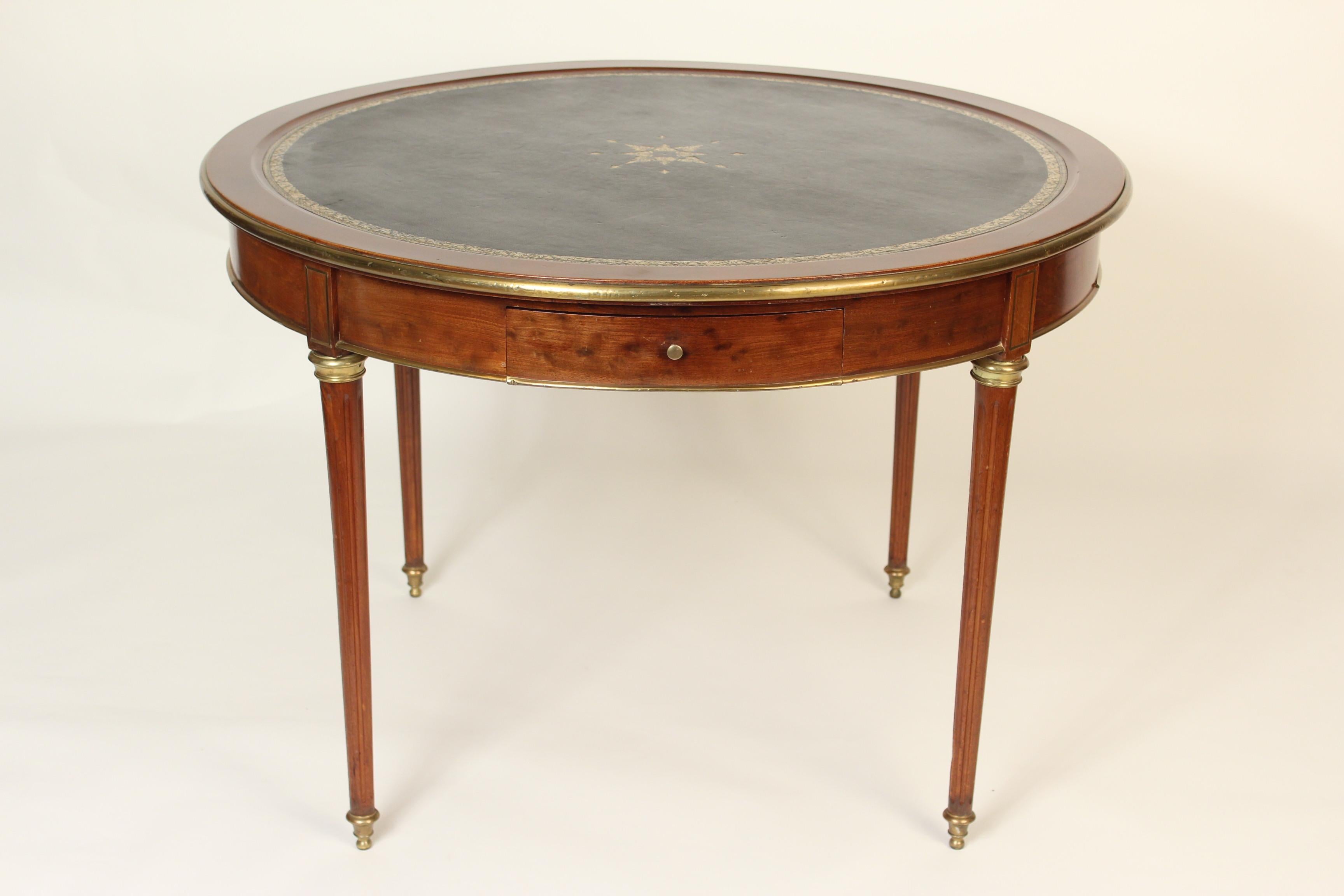 Louis XVI style mahogany games table with brass inlay, moldings, sabots and a tooled leather top, circa 1950. Hand dovetailed drawer construction.