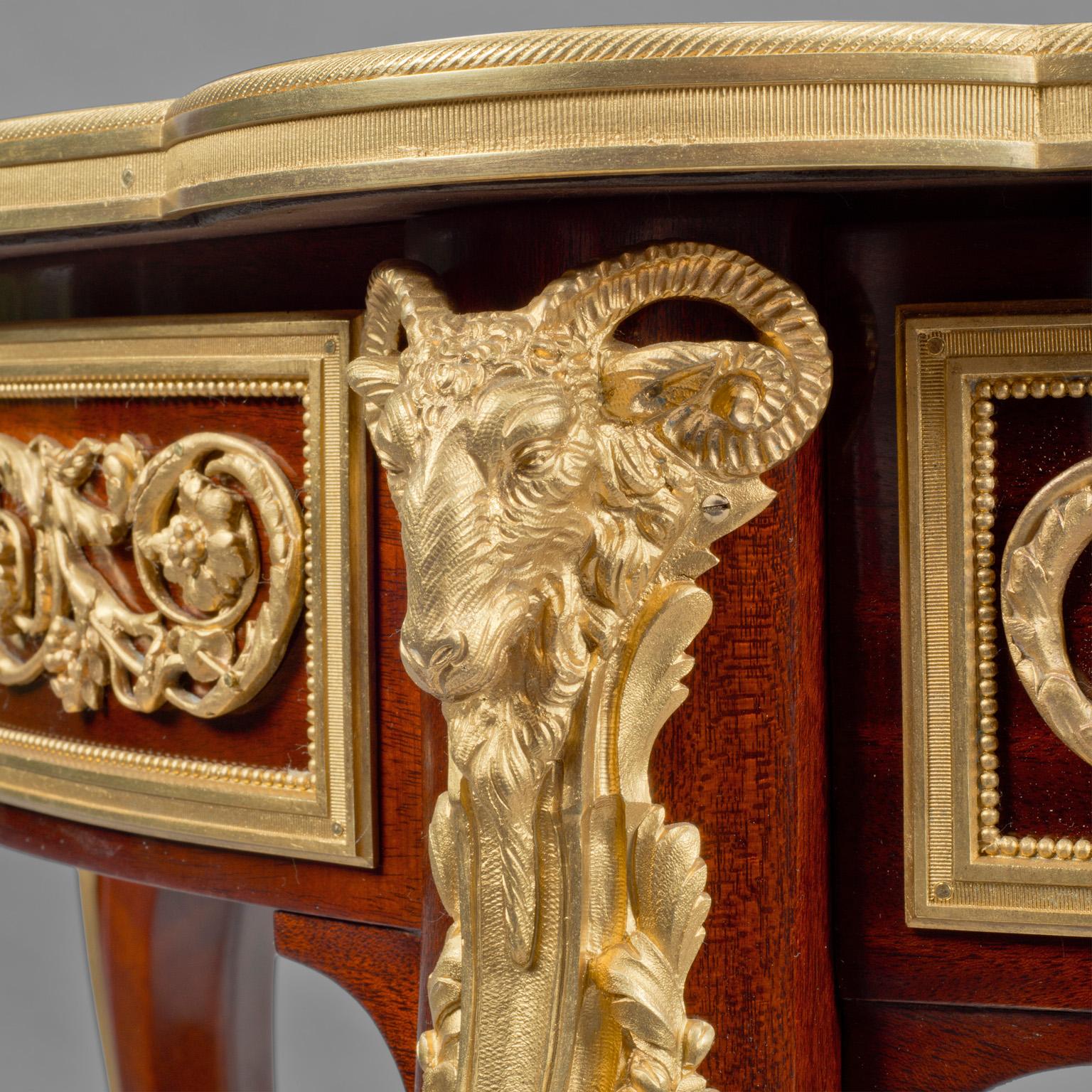 A fine Louis XVI style mahogany gilt bronze mounted Guéridon.

This fine gilt bronze mounted mahogany Guéridon has a green marble top inset within a gilt bronze frame, above a frieze with panels enclosing a gilt bronze mask of Apollo flanked by
