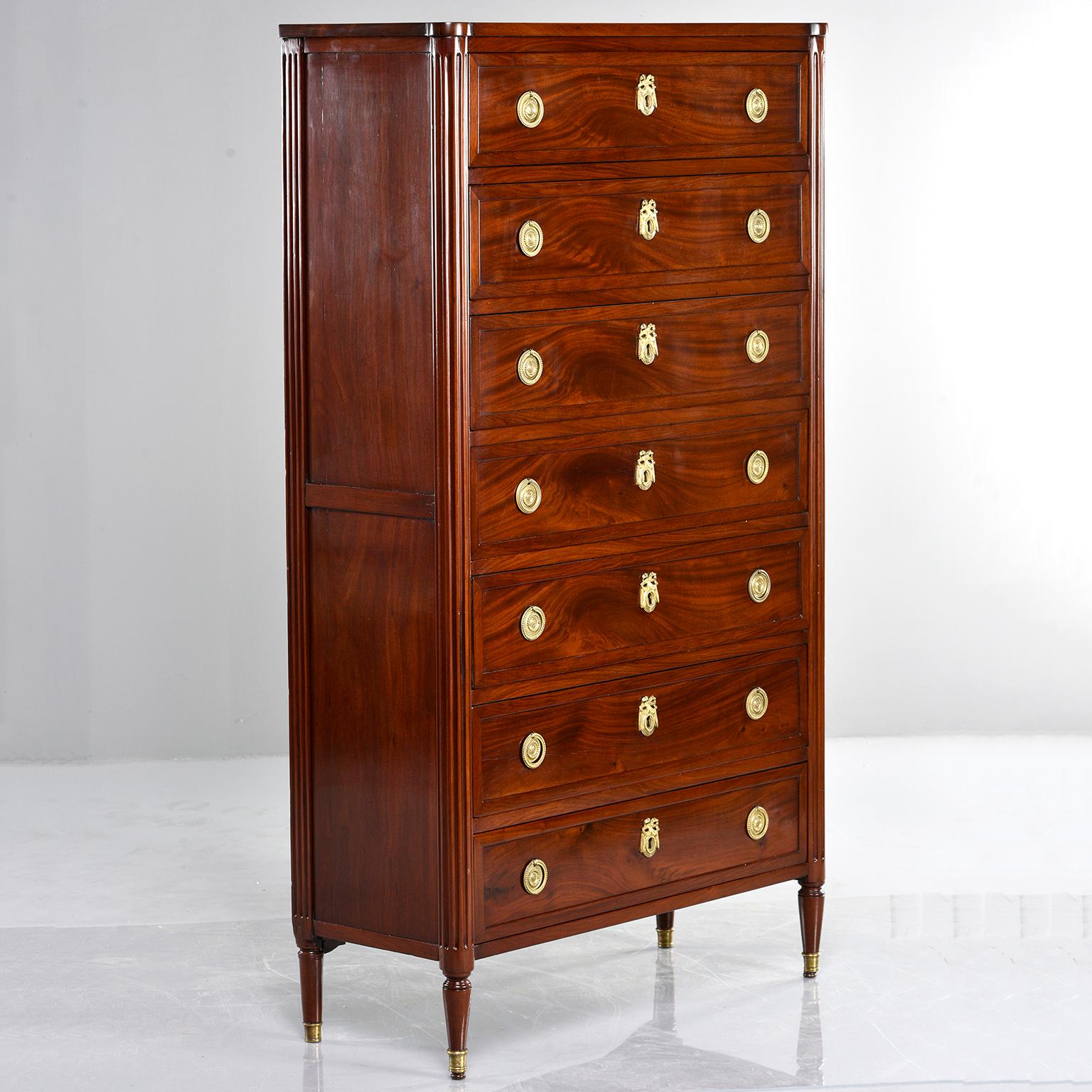 Louis XVI style mahogany semanier chest of drawers features brass hardware with functional lock and skeleton key, reeded and tapered side supports, seven drawers (semaine, the French word for week, is the root of the name for these classic seven