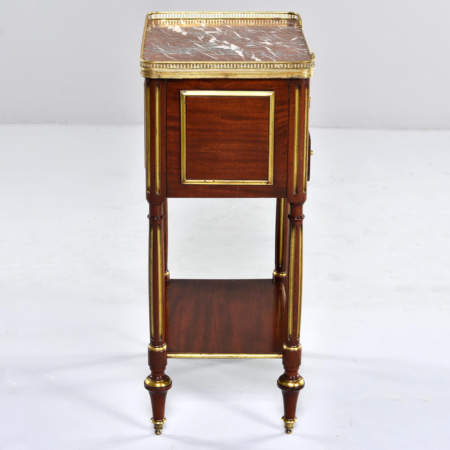 Louis XVI mahogany side cabinet has a marble top with brass gallery and two functional drawers with brass pulls, circa 1850s. Sides have brass trim, reeded legs have gilded details and turned feet.

Marble top has cracked corner - see detail photo.