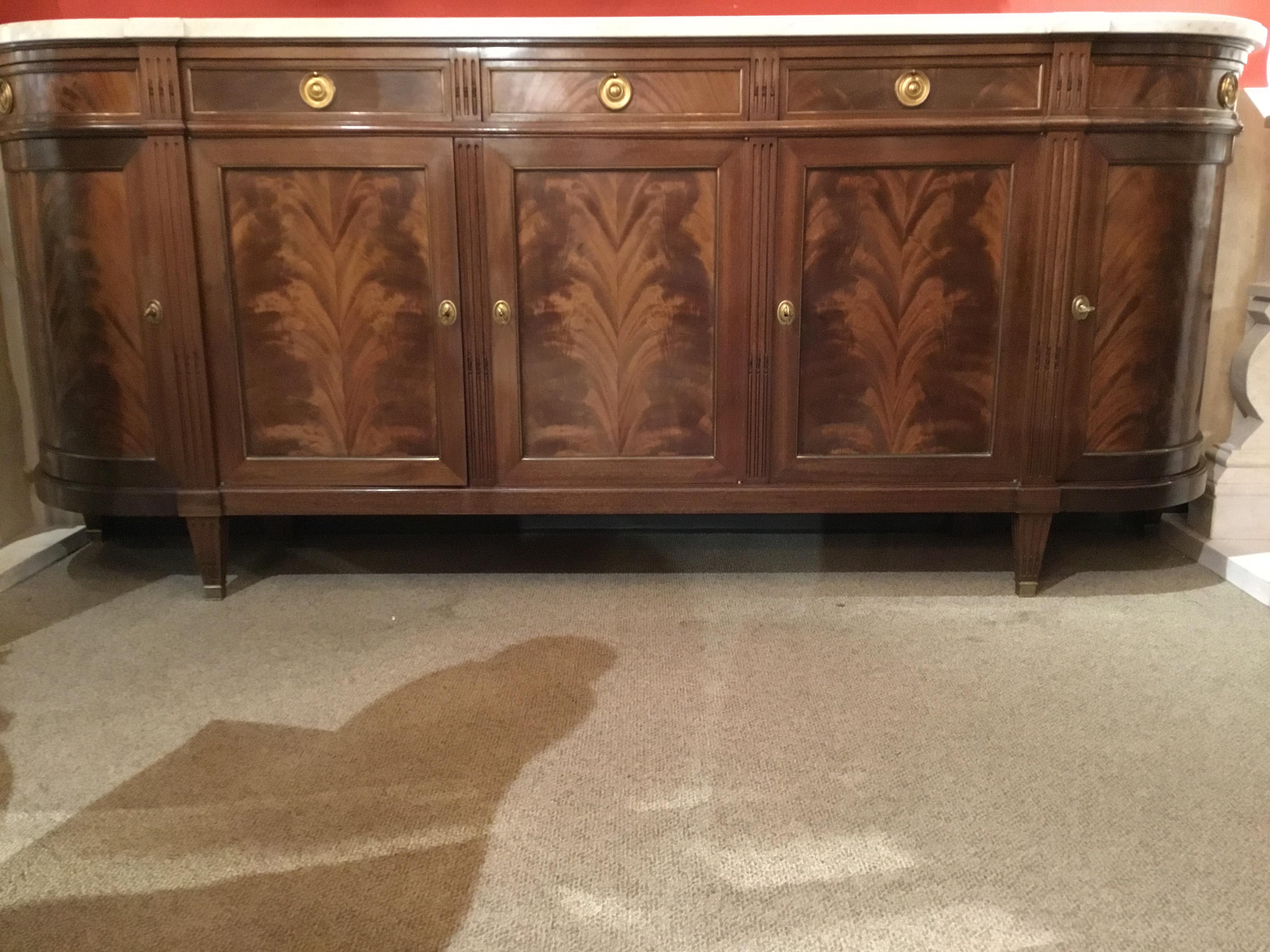 French sideboard with graceful curved sides and white marble. Beautifully
matched flame mahogany all the way across this piece. Gilt bronze hardware
Adorn this buffet. Great storage with movable shelves. Five drawers across
the top that draw very