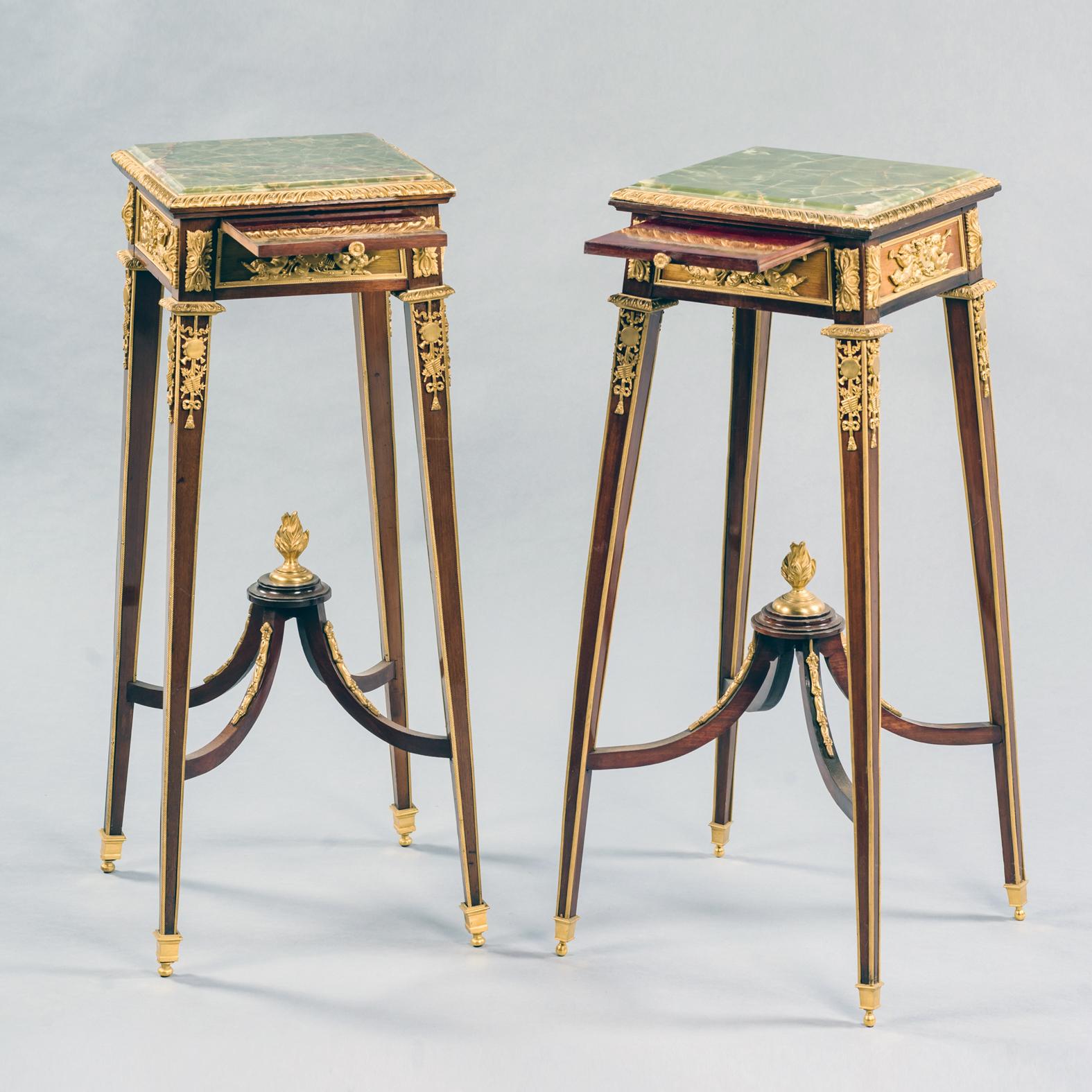 A fine pair of Louis XVI style gilt bronze mounted mahogany stands, firmly attributed to François Linke.

This delicate pair of mahogany pedestals or stands each have an inset green onyx top above a frieze mounted with allegorical scenes of music.