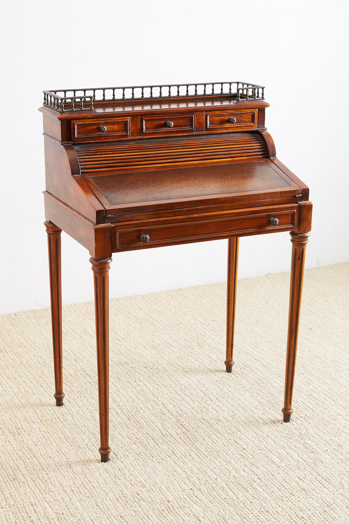 Elegant French Louis XVI style mahogany tambour writing table or desk also known as a Bureau De Dame, or cylinder desk. Features a roll top design with a flip top leather writing surface that measures 24 by 16 inches. Created by Maitland-Smith's