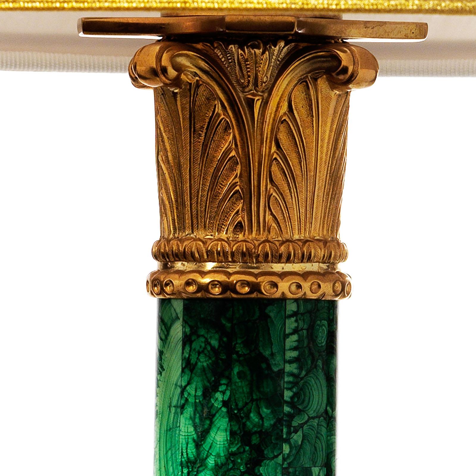 Louis XVI style malachite and gilt bronze column table lamp by Gherardo Degli Albizzi.
This lamp has a very refined design featured by a classic vegetal motif capital and masks inscribed in vegetal festoons. Malachite veneer work, with its