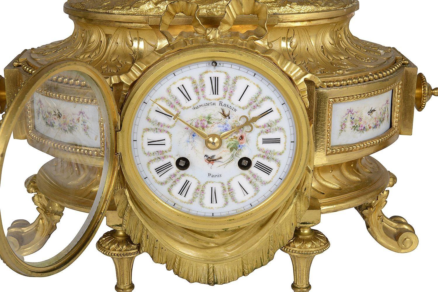 A fine quality 19th Century French gilded ormolu and hand painted porcelain clock garniture, having a statue of a mother and child playing musical instruments above a eight day duration clock that strikes on the hour and half hour, matching