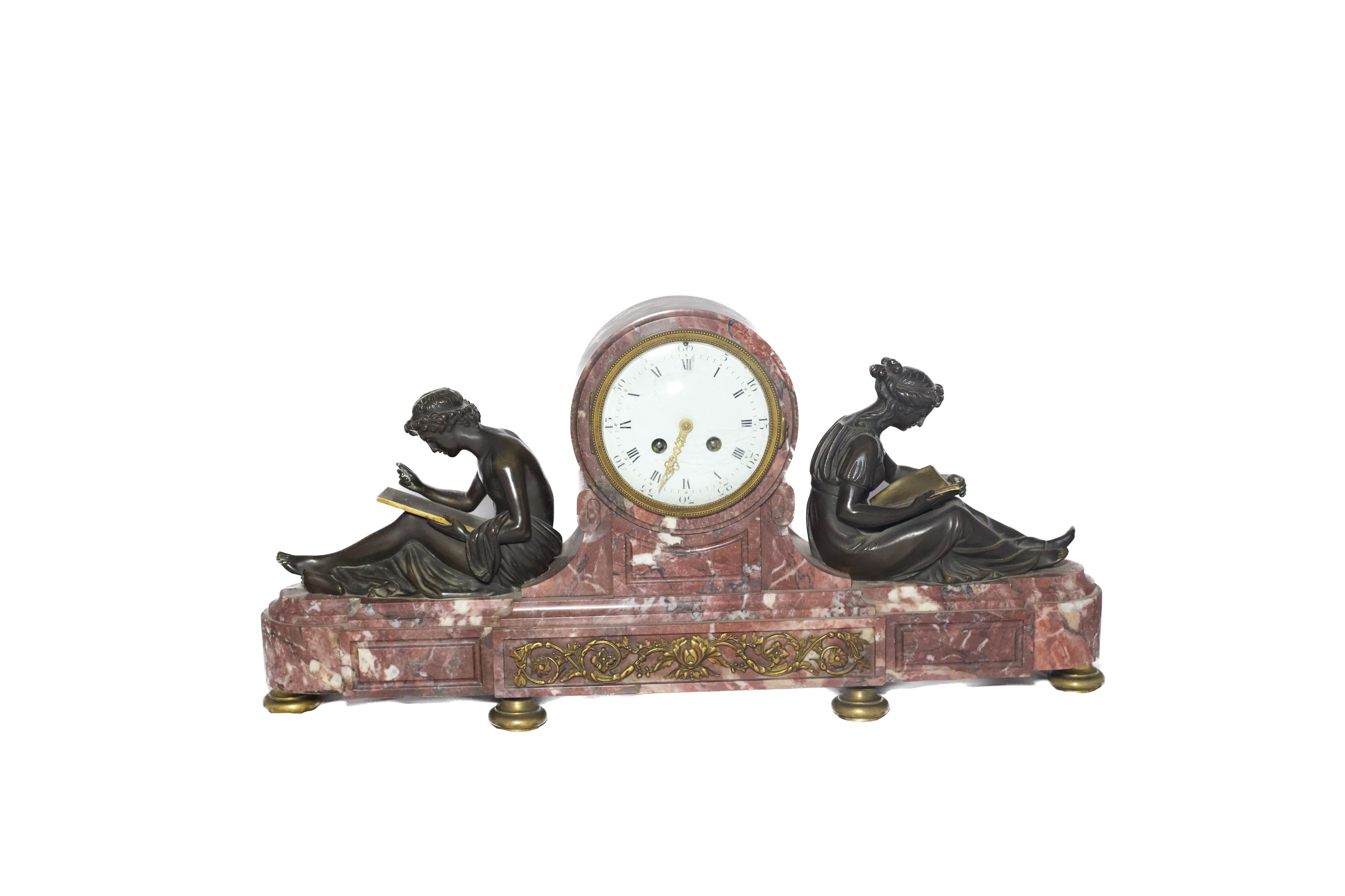 This exquisite Louis XVI-style clock is crafted from fine marble and adorned with patinated bronze figures that symbolize the study of art and science. The harmonious composition features beautifully detailed bronzes, representing classical motifs,