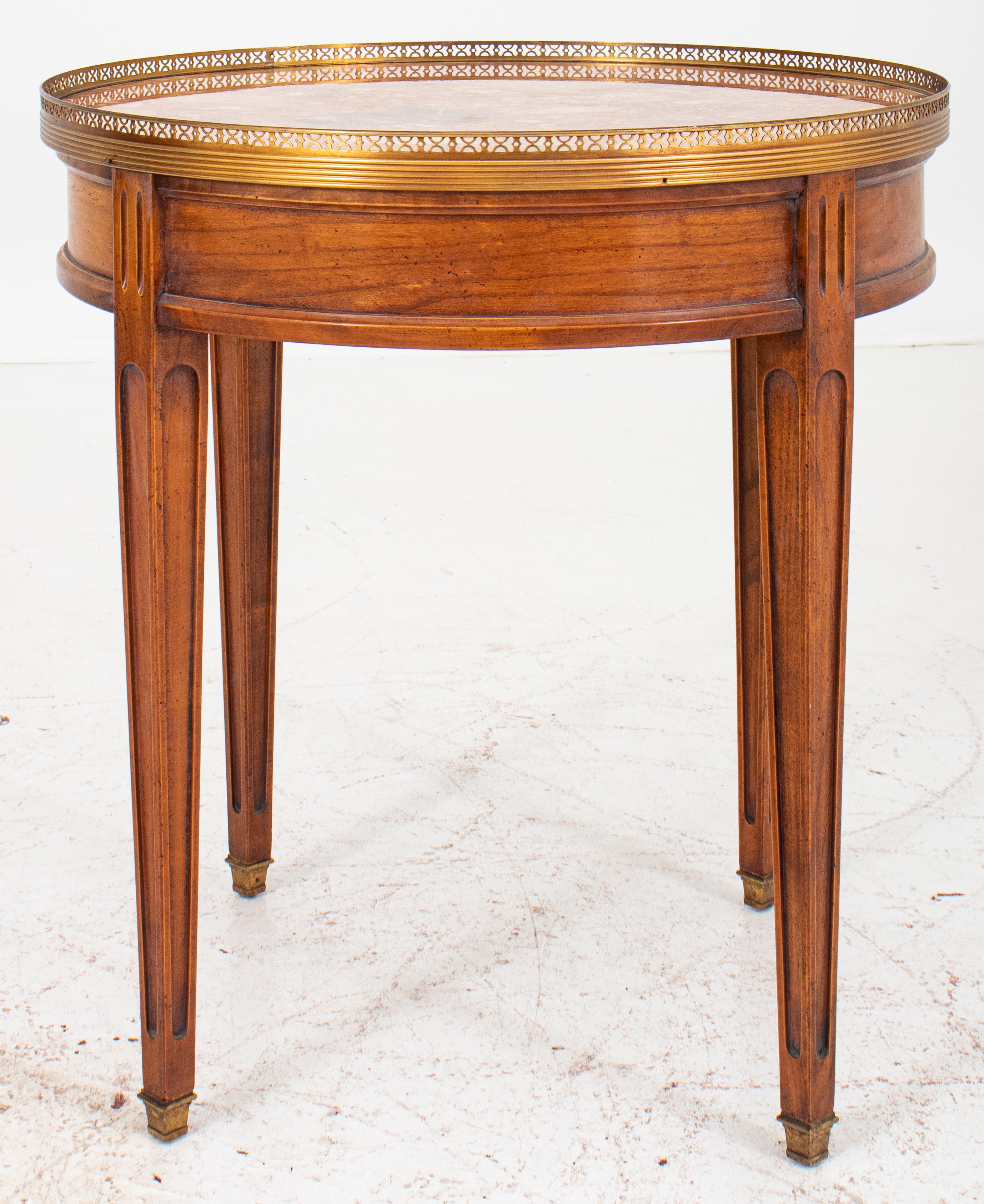 Louis XVI style red marble mounted mahogany table a bouillotte or lamp table, round, the red marble top with -on a reticulated gilded-brass gallery, the table with one drawer, on tapering square paneled legs terminating in conforming giltmetal