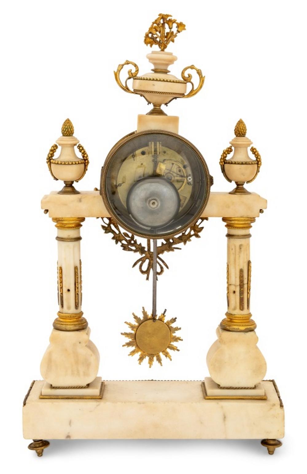 Louis XVI Style Gilt Metal Mounted White Marble Portico Mantel Clock, late 19th century, the circular enamel dial with strike on bell movement, surmounted by two handled urn and bouquet, with sunburst pendulum, over fluted columns, the rectangular