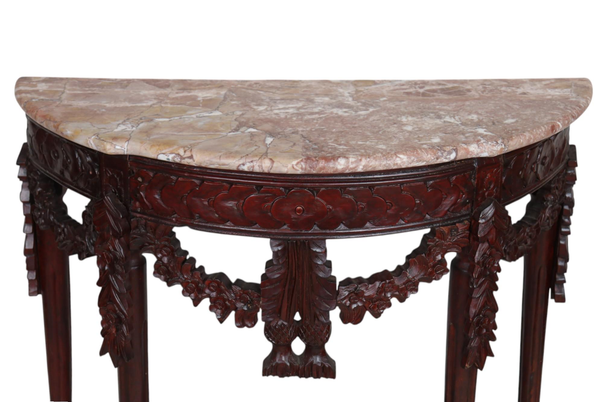 A Louis XVI style hall table. Demilune shaped Arabescato rosso marble forms the top, with a rounded serpentine edge. The skirt is carved with simple rosettes and floral swags. Fluted tapered legs finish with arrow feet, supported with a half curule
