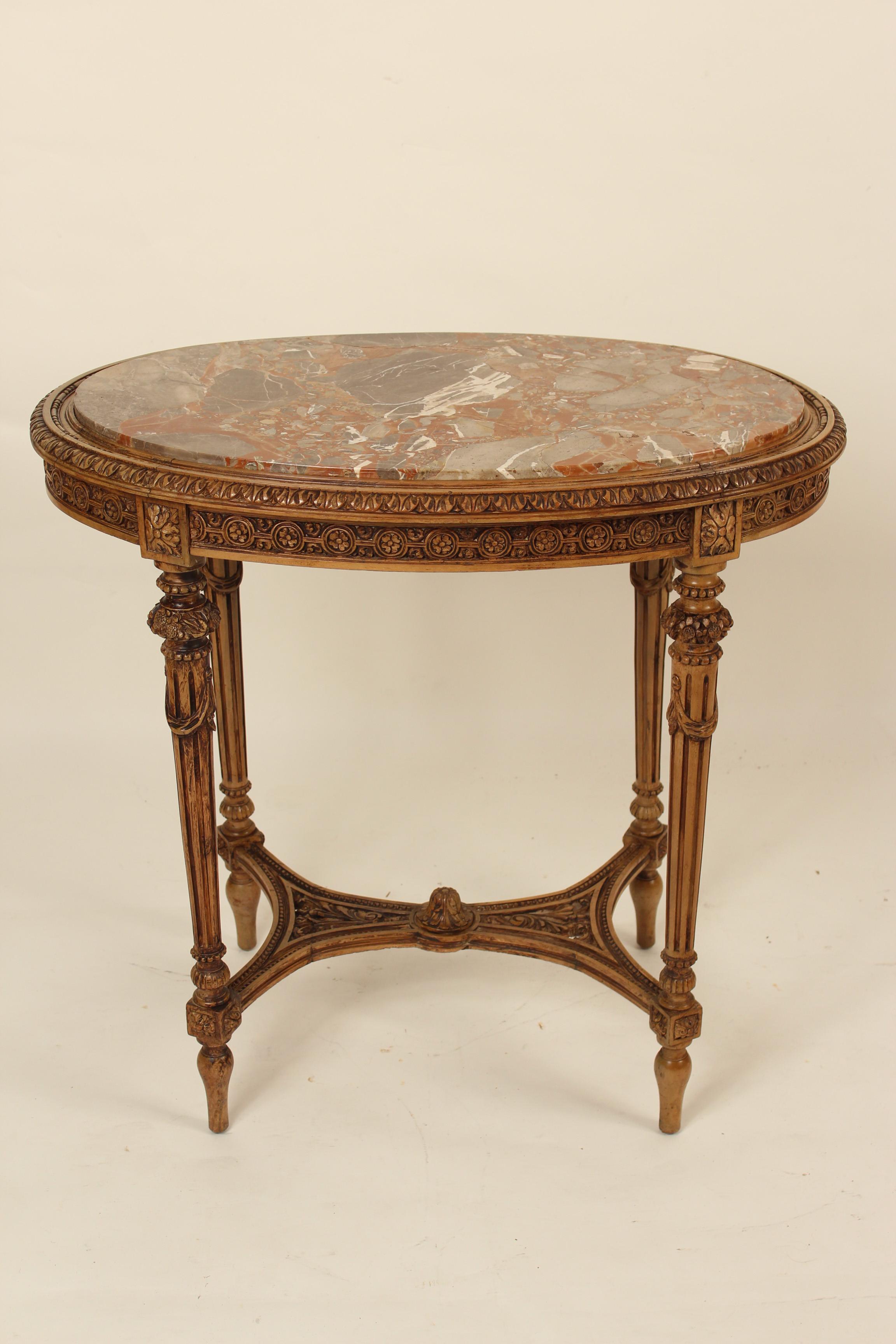 Louis XVI style carved oval beechwood occasional table with marble top, circa 1930. Exquisite carving on this table.