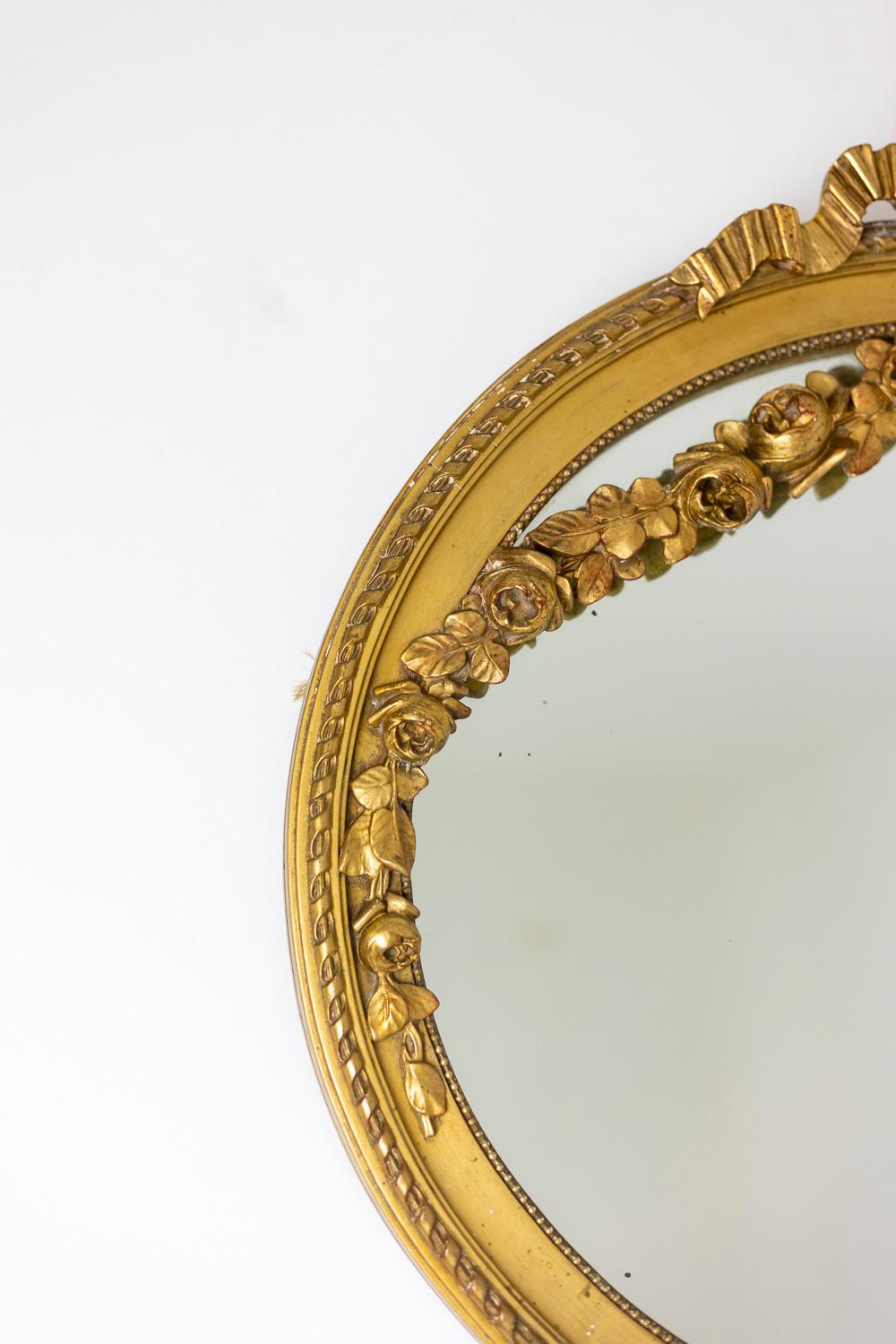 Spiegel aus vergoldetem und geschnitztem Holz, verziert mit einem Band, Blumengirlanden und einem perlenbesetzten Fries, oval.

Französisches Werk, um 1880 hergestellt.

Abmessungen: H 66 x L 68 x P 7 cm (ca. 66 x 68 x 7).

