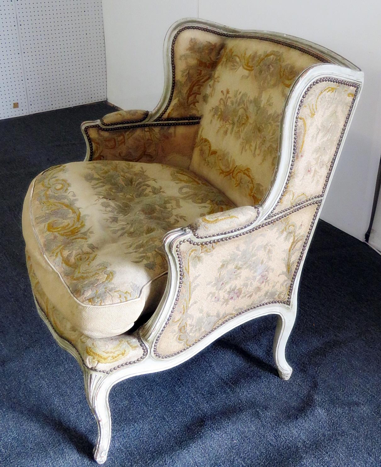 Louis XVI style distressed painted bergere with needle point upholstery and nail head trim.