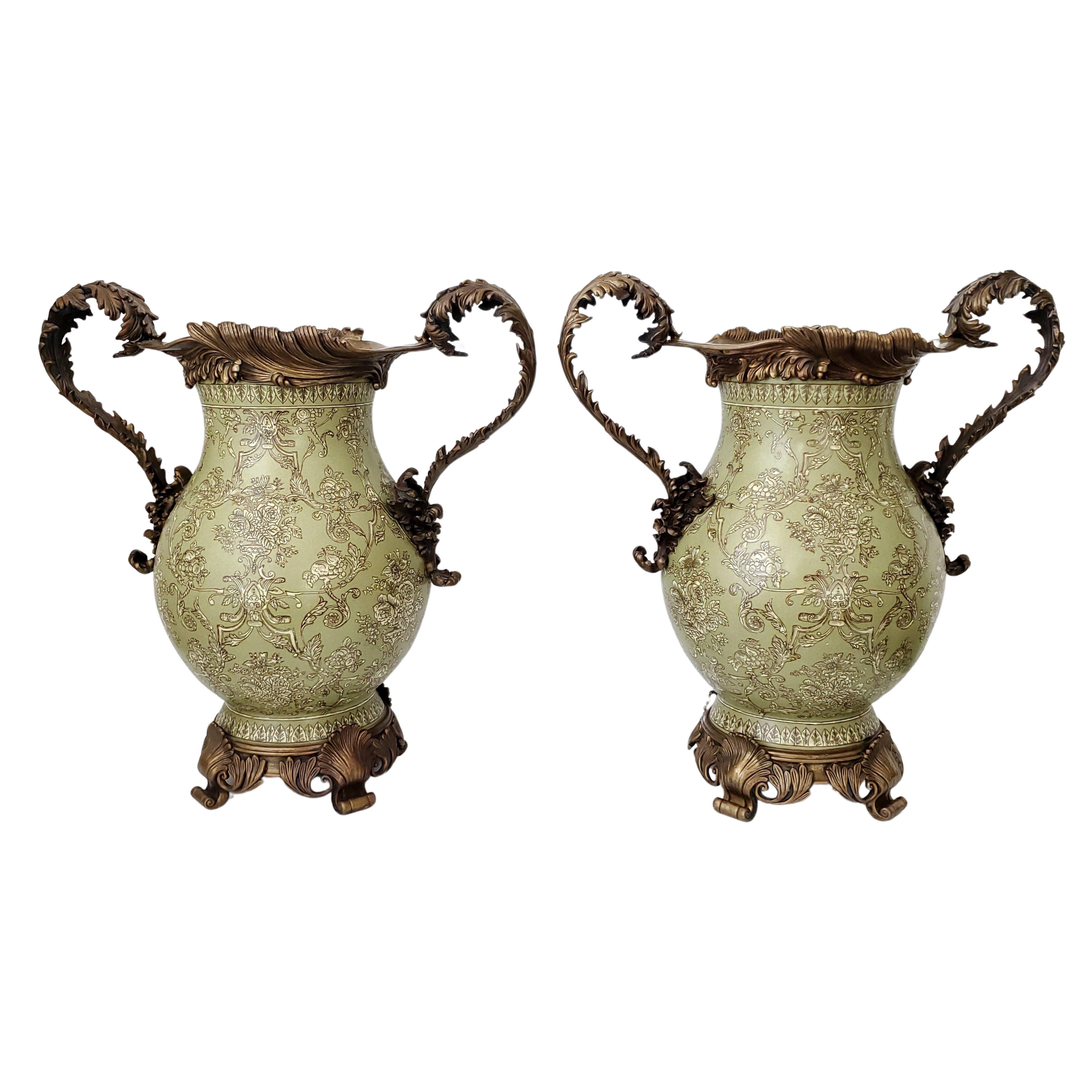 Monumental pair of vintage Chinoiserie urns decorated with ornate brass ormolu style handles, bases and rims, circa 1970s. 
The body of the large urns are heavy porcelain with intricate designs of textured roses and arabesque geometric patterns with