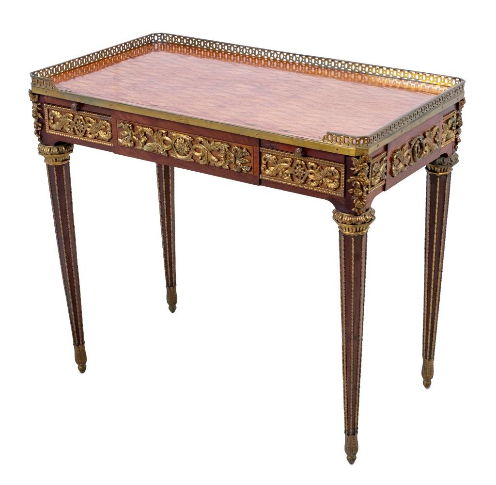 Tavolo da scrittura con intarsio in mogano e tulipano montato a Ormolu, secondo il modello di Jean-Henri Riesener, fine del XIX secolo. Il piano intarsiato in parquet è dotato di una galleria a tre quarti sopra cassetti terminali e guide estraibili,