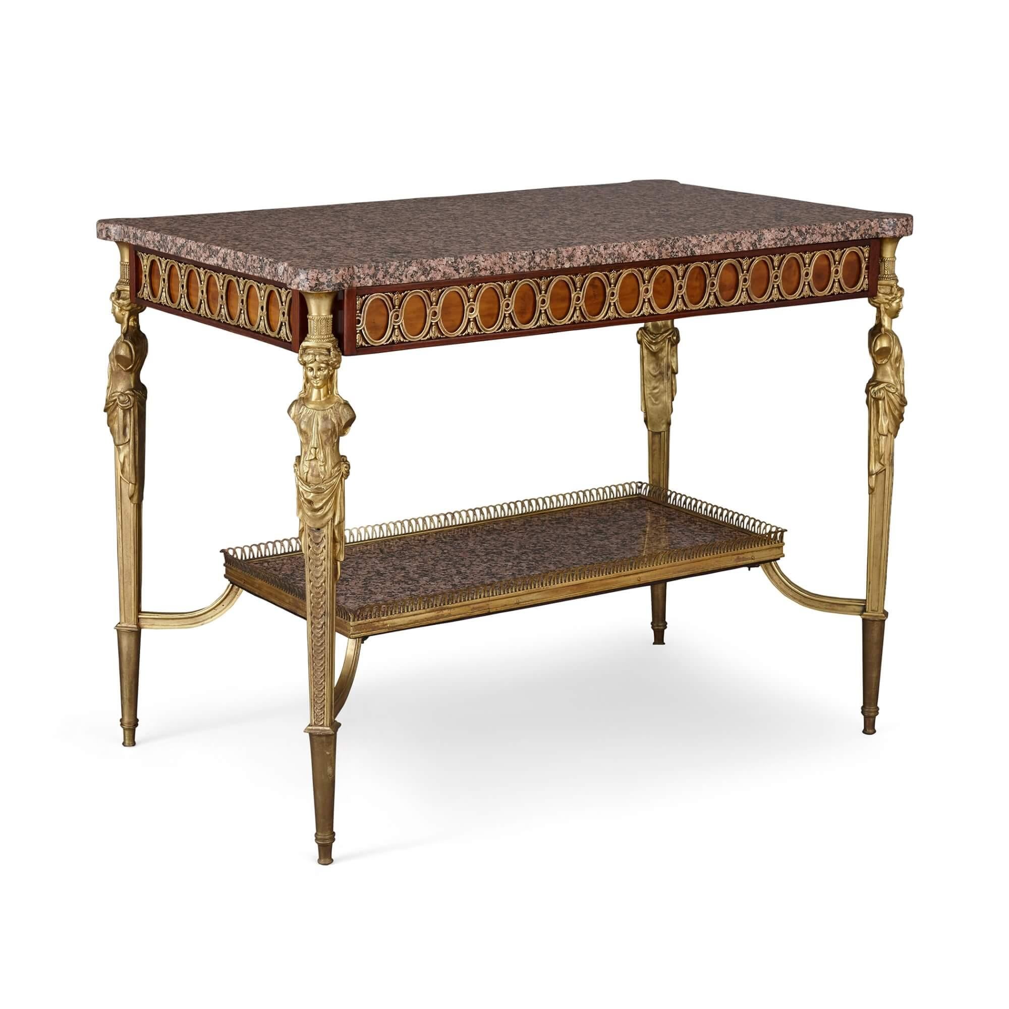 With a large rectangular pink granite surface resting upon a guilloche frieze, this fine antique centre table, crafted in the early twentieth century, mixes both Rococo and Neoclassical elements in the Louis XVI style. The four legs are crafted in