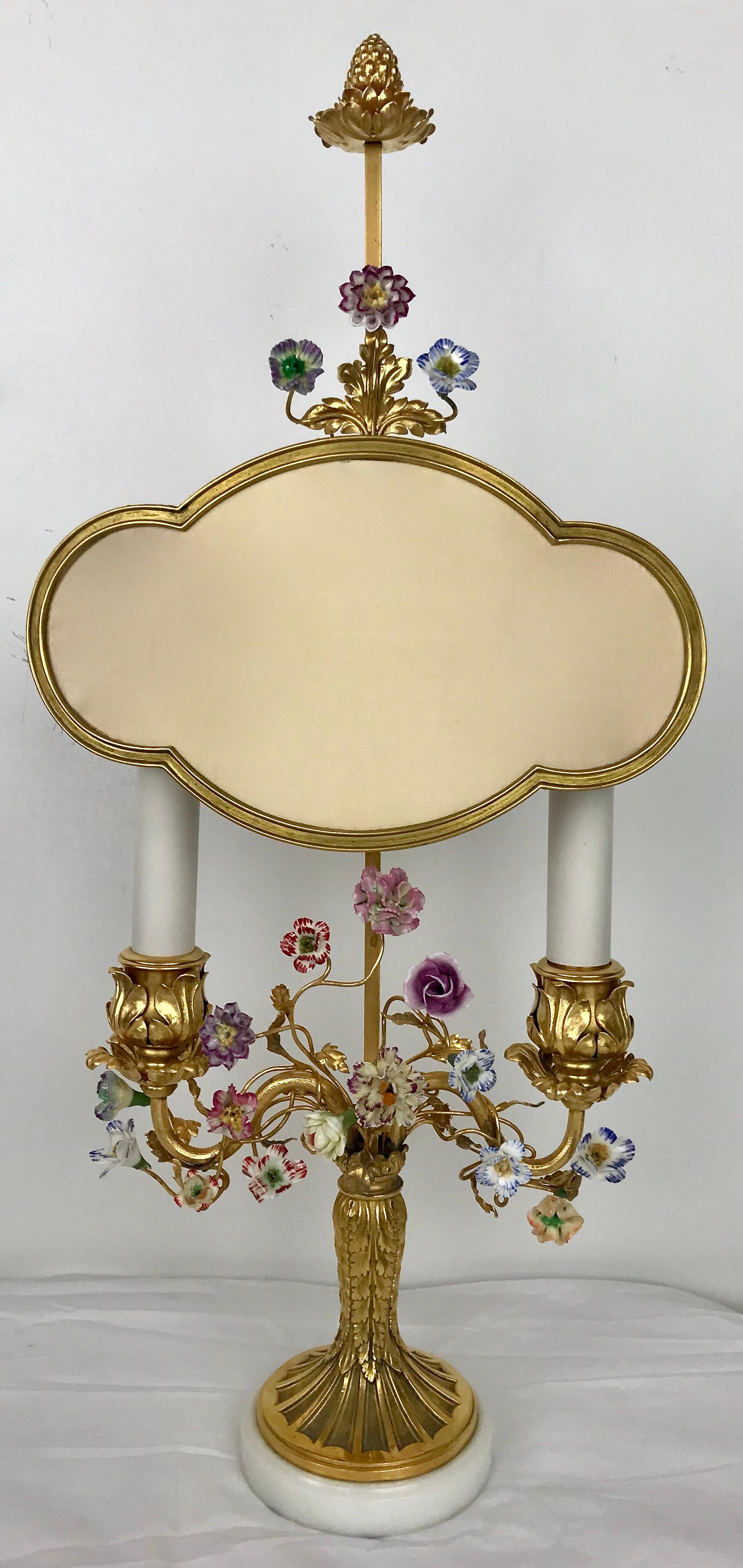 Este estilo Luis XVI de gran calidad  lámpara bouillotte de bronce, montada sobre una base de mármol de Carrara presenta flores de porcelana pintadas a mano y naturalistas
hojas y ramas de bronce dorado. La lámpara tiene una pantalla ajustable de