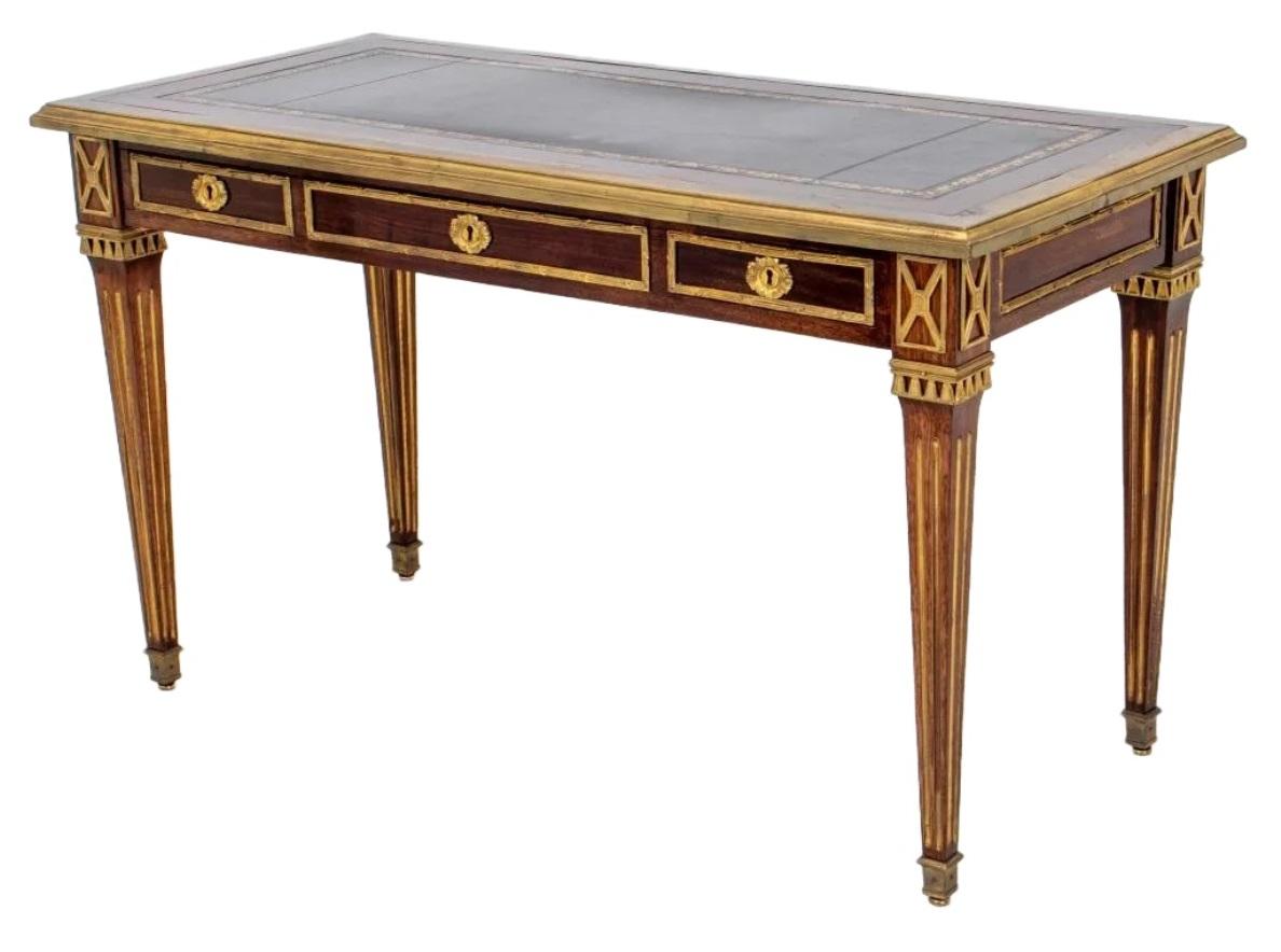 Elegant Louis XVI style ormolu mounted mahogany desk or bureau plat, circa 1950's , 
attributed to Maison Jansen, rectangular, the gilt tooled leather inset top bordered by a gilded steel molding above three short drawers with ormolu mounts and key