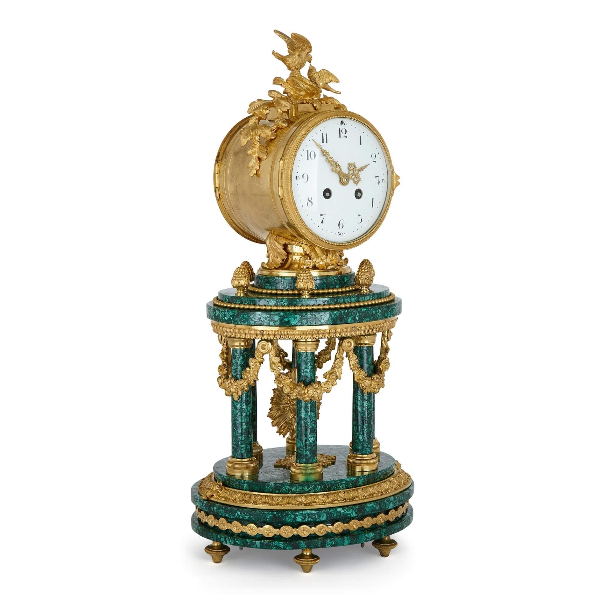 Pendule de cheminée de style Louis XVI à colonne en malachite montée en bronze doré.
France, fin du 19e siècle.
Dimensions : hauteur 52 cm, largeur 23 cm, profondeur 20 cm.

Avec son cadran circulaire enchâssé dans un boîtier rond, cette belle