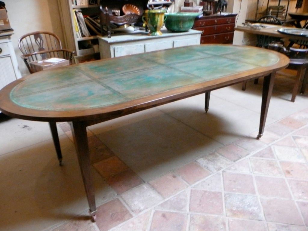 Unique Louis XVI style oval dining table with copper top. Straight tapering legs made of ash with brass castors. Deeply patinated “Verdigri” copper top with eight panels and over 1100 hand-hammered copper rivets. Perfect for a country home or unique
