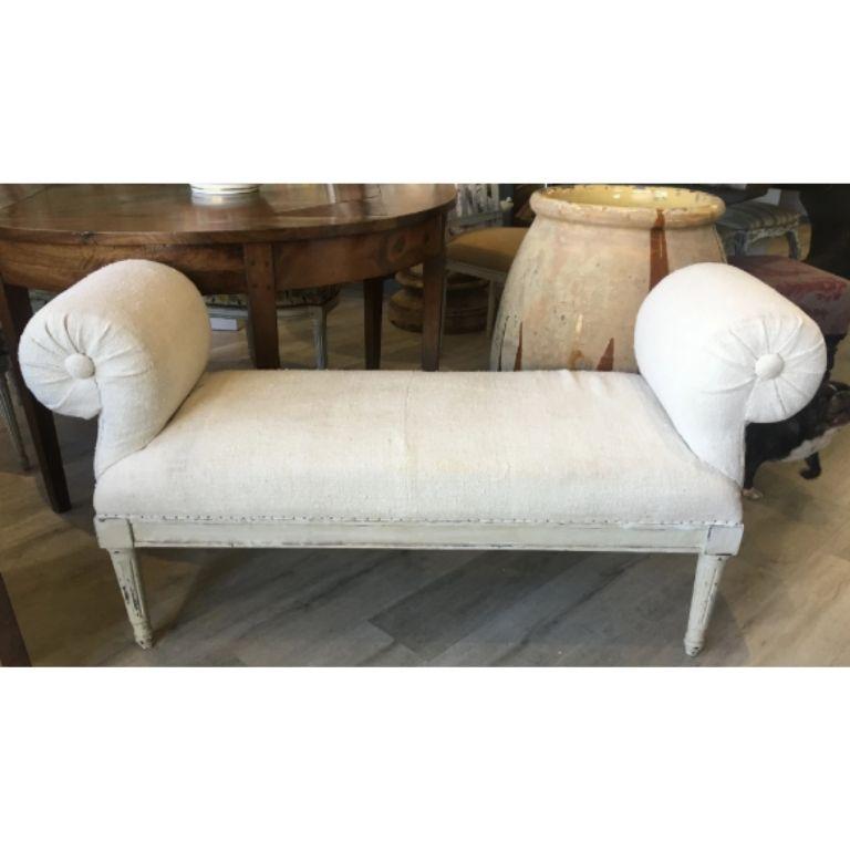 Louis XVI style bench or banquette late 19th century-early 20th century, with exuberantly scrolled arms. Upholstered in cream nubby linen. Measures: Seat height 17 1/2