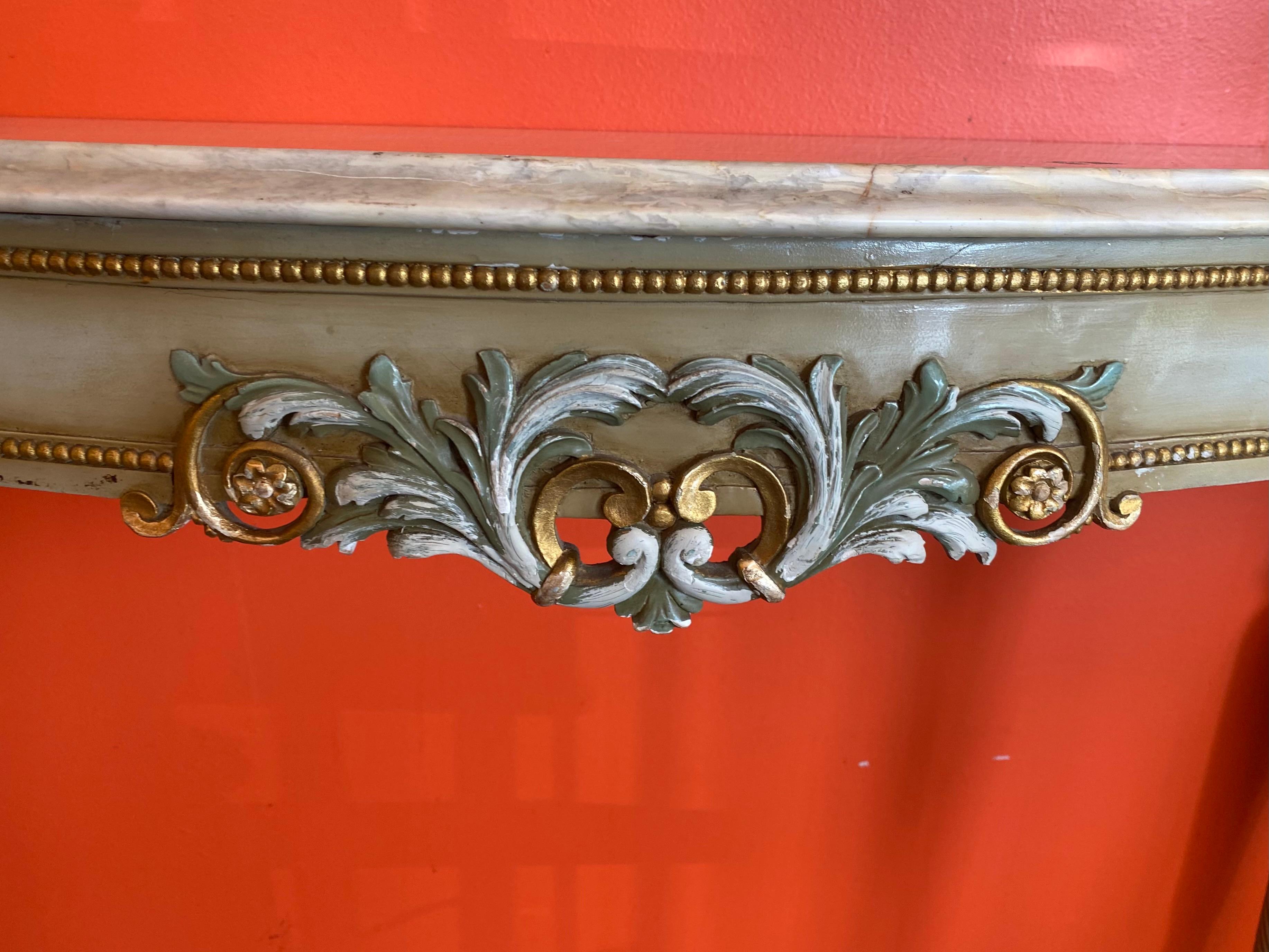 Louis XVI style parcel gilt and paint decorated console table, 20th c., shaped stone top, over conforming apron with foliates, beaded molding, rising on spiral tapered legs.