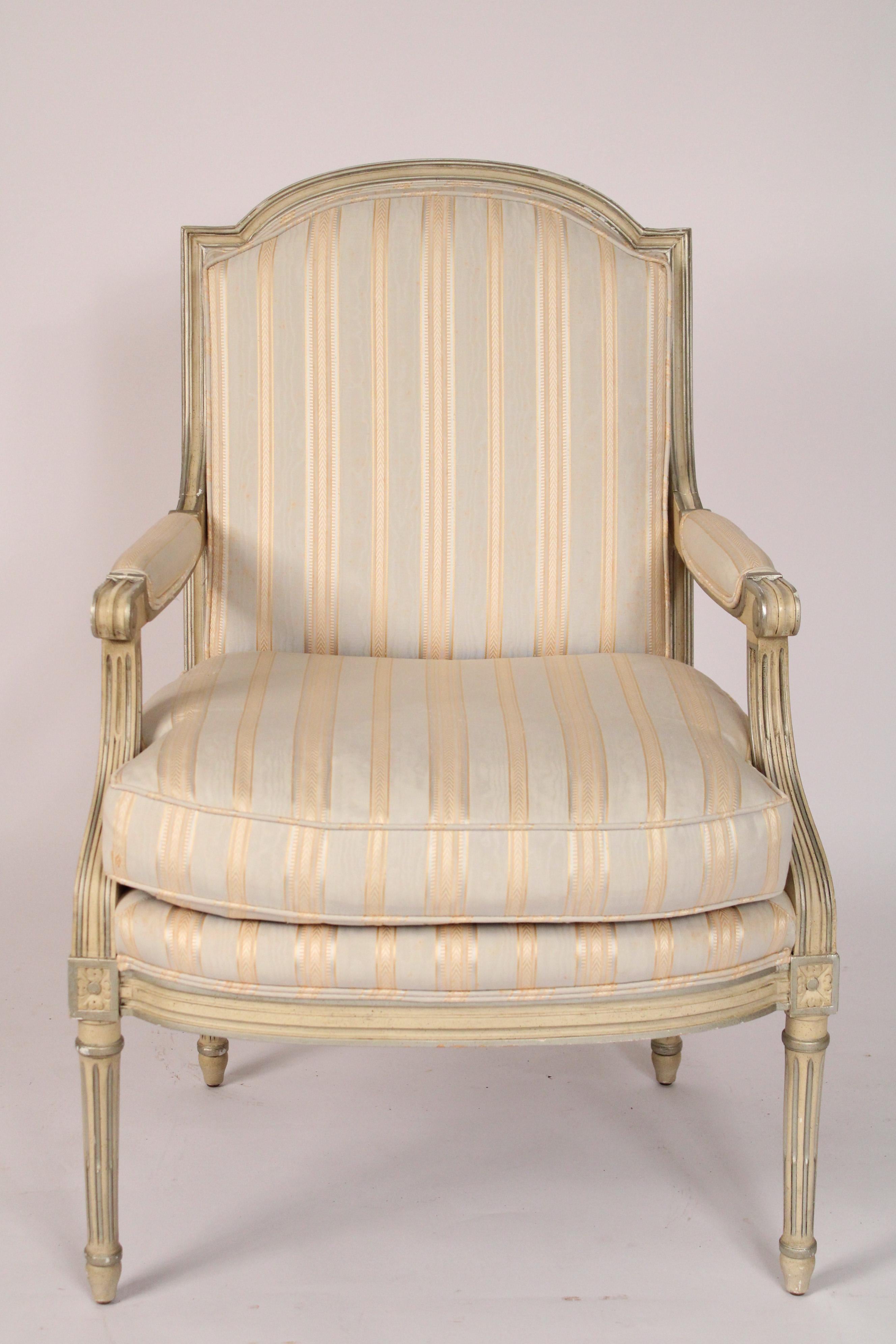 Louis XVI style painted armchair, made by Baker Furniture Company, circa 2000. The paint is off white and silver. The cushion is partial down filled, see photo of upholstery contents.