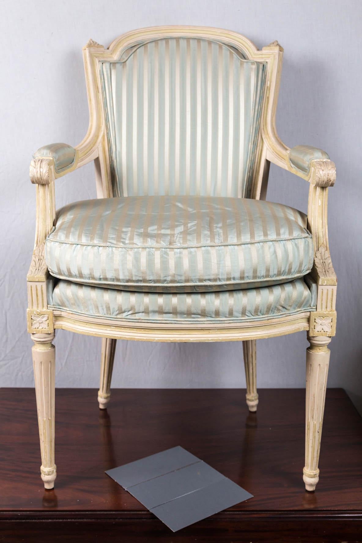 Of a small scale, with upholstered back and loose cushion. Rounded top rail, round tapered fluted legs. Decorated with typical Louis XVI elements and fluting.